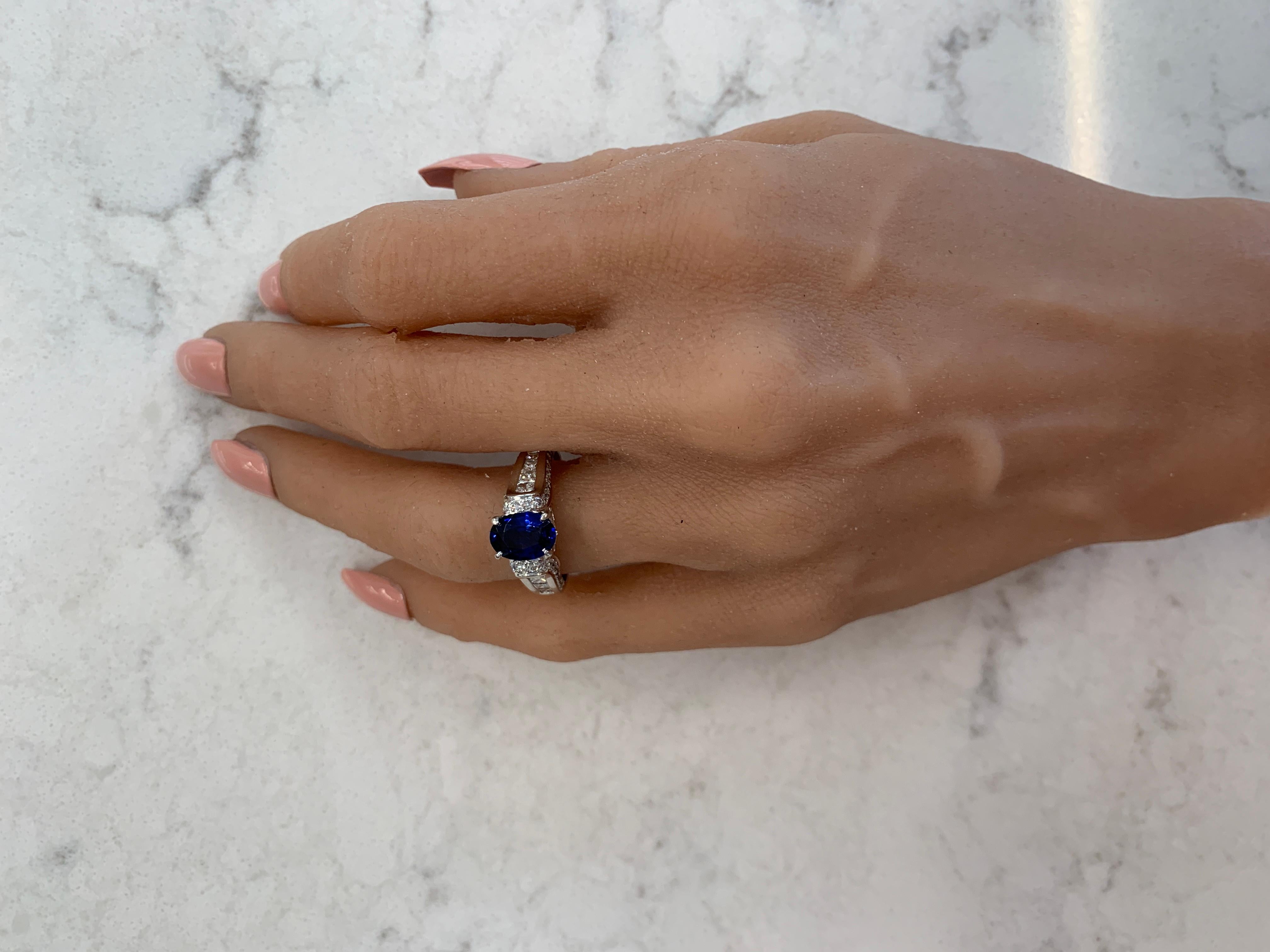 This is a 1.71 carat oval cut blue sapphire. The gem source is Sri Lanka; its color is royal blue and it is evenly distributed throughout the gem. Its luster and transparency is superb. Sparkling round brilliant cut diamonds total up to 1.11 carats.