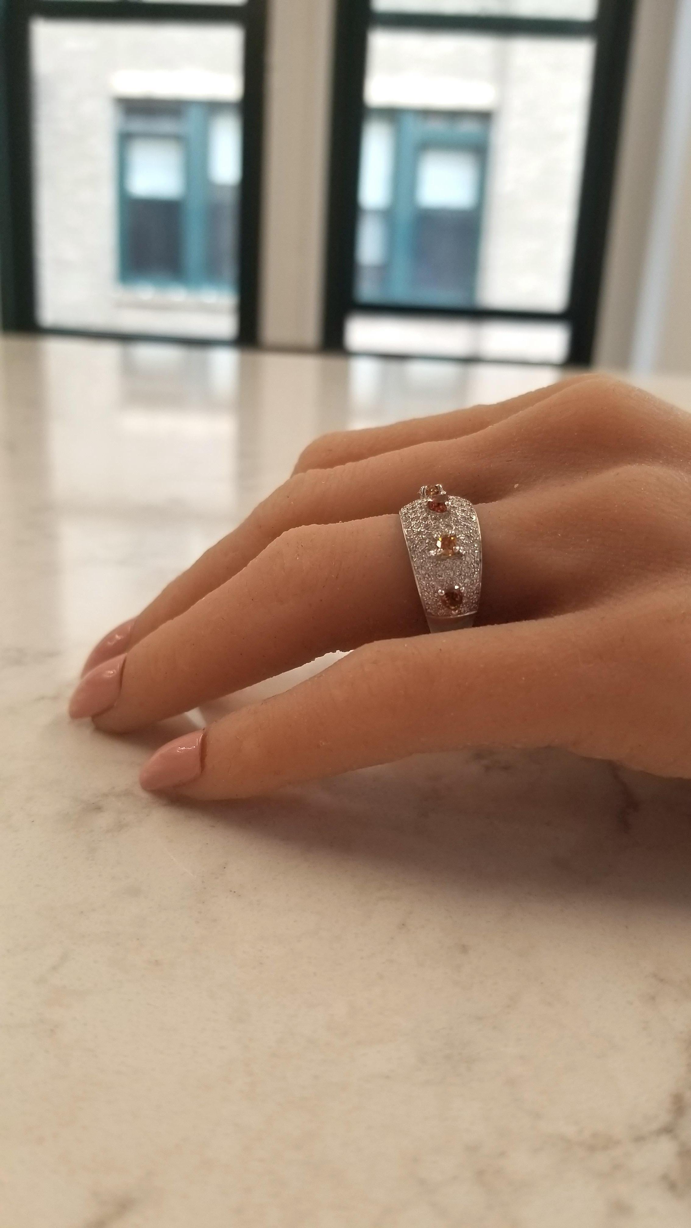 This is a cocktail band featuring 0.69 carats of 6 fine quality natural fancy intense orange-brown diamonds that exhibit the finest cognac colors in the world. Designed for divergence, 1.03 carats of 132 scintillating round brilliant cut white
