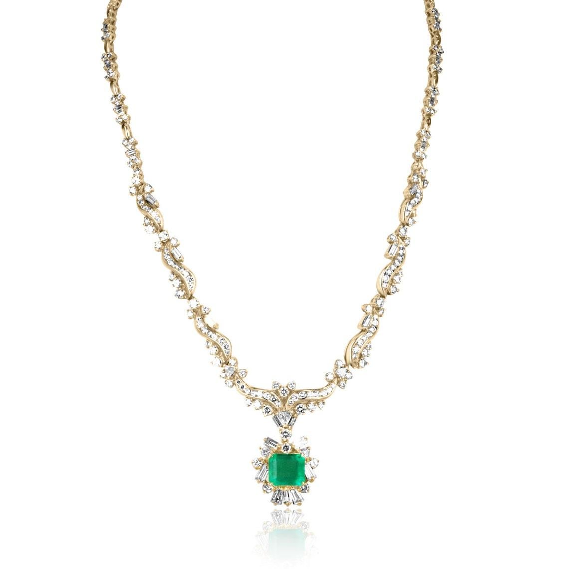 This breathtaking emerald and diamond statement necklace is a masterpiece fit for royalty. At its center lies a magnificent emerald-cut Colombian emerald, radiating a rich and vivid green hue, set east-to-west in a classic four-prong setting.