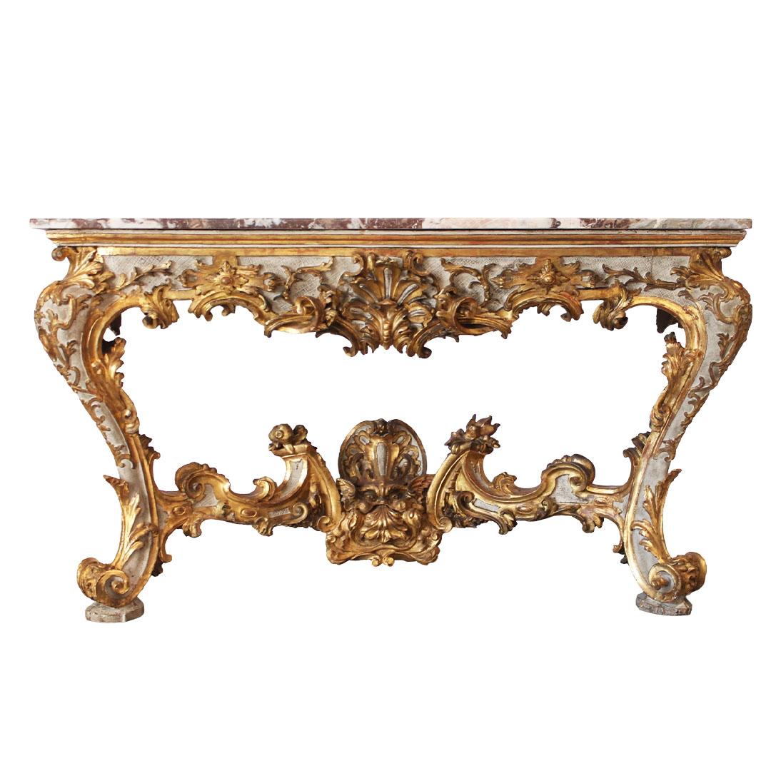 An Venetian early 18th century Rococo period carved giltwood console table with red variegated marble top and painted accents. This Italian console table features a rectangular variegated marble top, sitting above a stunning carved giltwood base,
