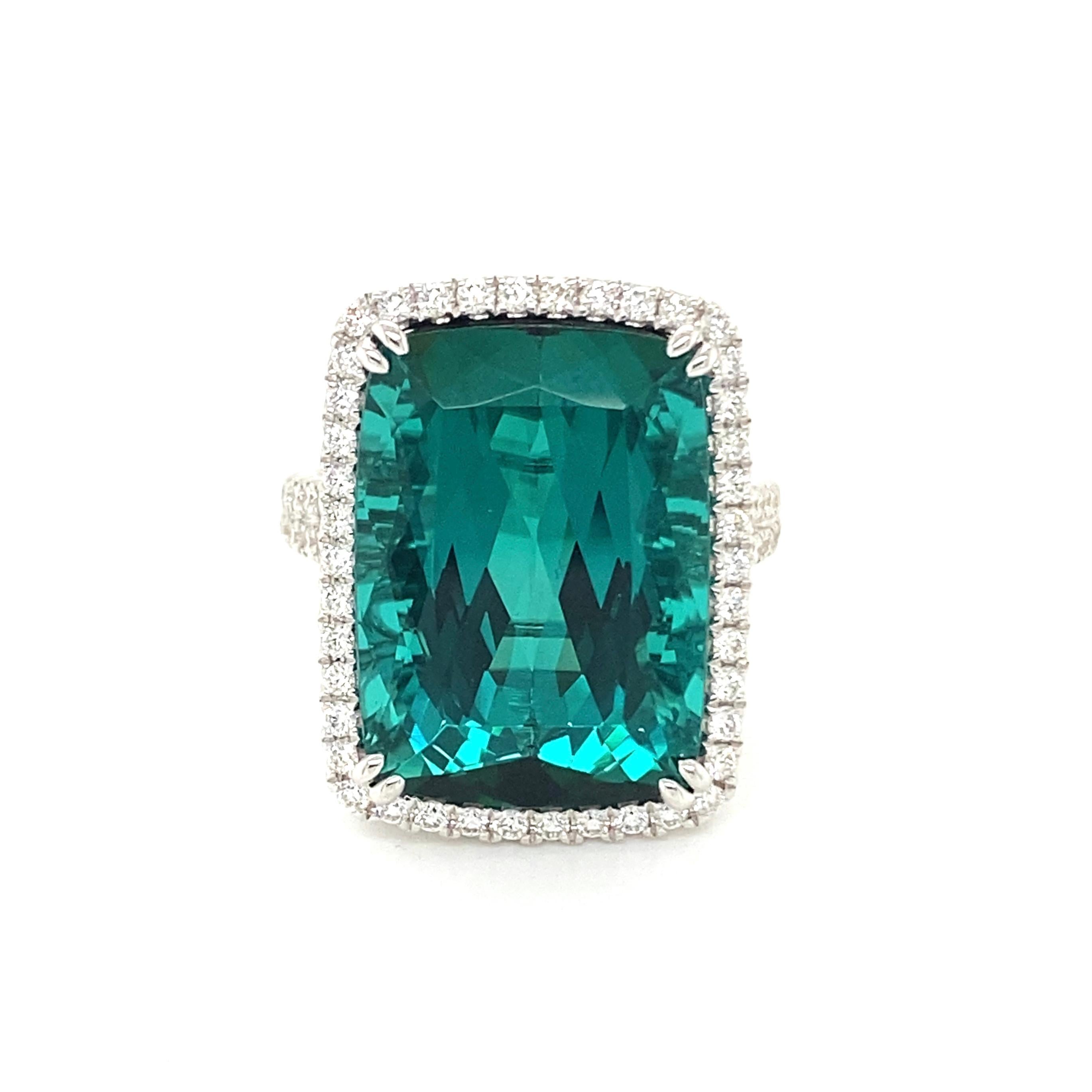 This stunning cocktail ring showcases a beautiful 17.25 Carat Cushion Blue Green Tourmaline with a Diamond Halo on a Double Diamond Shank. This ring is set in 18k white gold.
Total Diamond Weight = 0.83 Carats. Ring Size is 6 1/2.