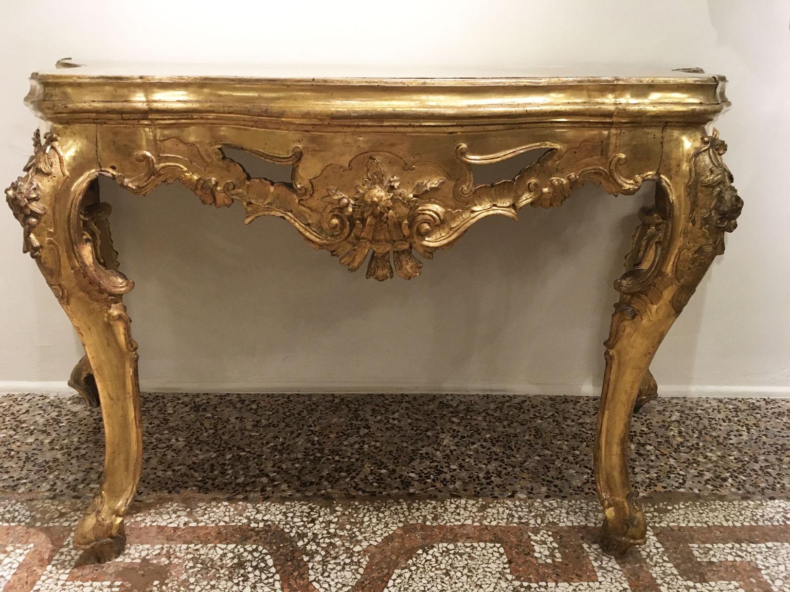This is an exquisite gilded and carved console, with the top made in onyx marble. The front and side parts are carved with scrolls that create a delicate carving effects. The onyx top and the walnut base, hail from Mid- 18th Century, Venezia, Italy.