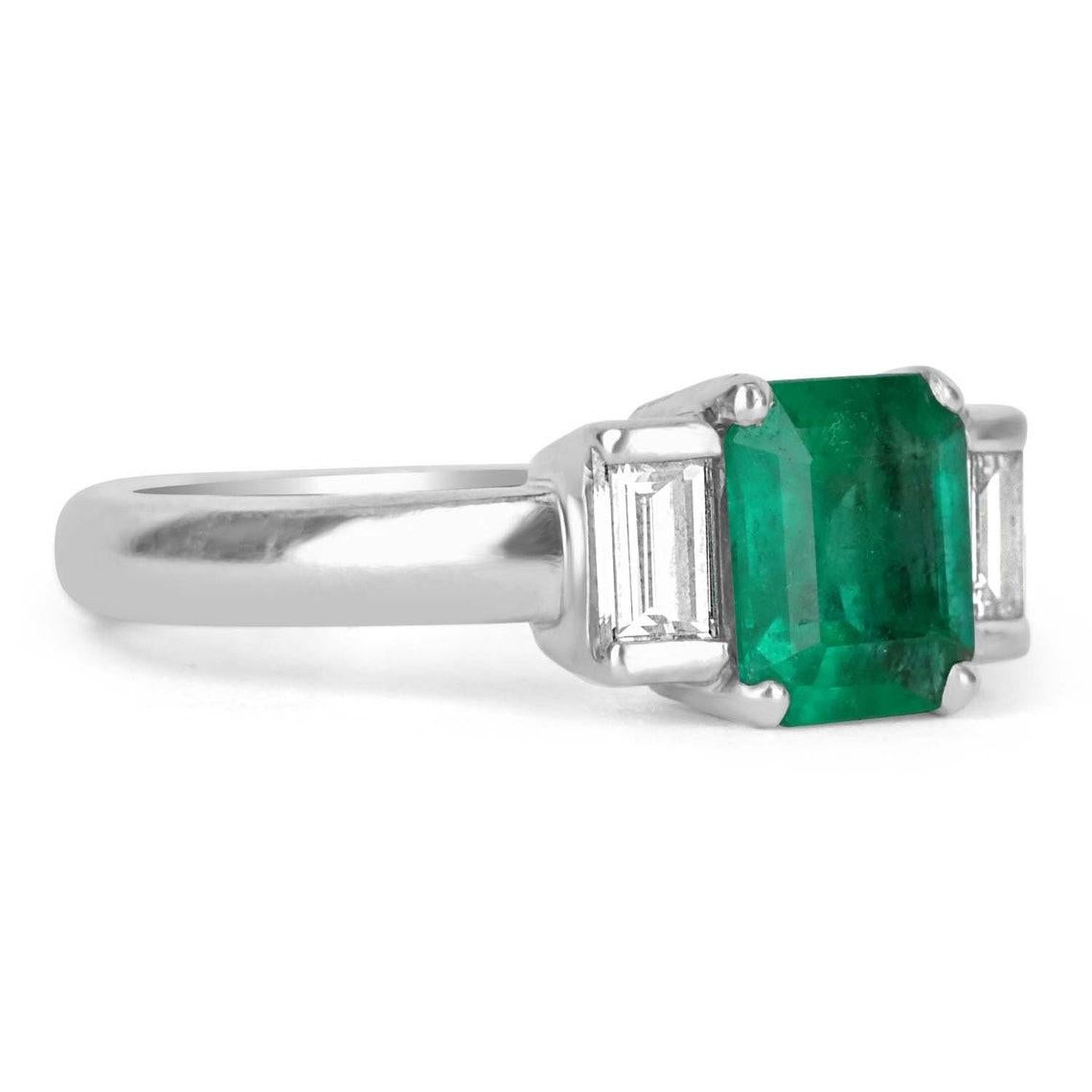 Setting: Three-Stone
Metal Purity: Platinum
Metal Weight: 7.4 Grams

Main Stone: Emerald
Shape: Emerald Cut
Approx Weight: 1.18-Carats
Color: Green
Clarity: Transparent
Luster: Excellent-Very Good
Origin: Colombia
Treatment: Natural

Secondary