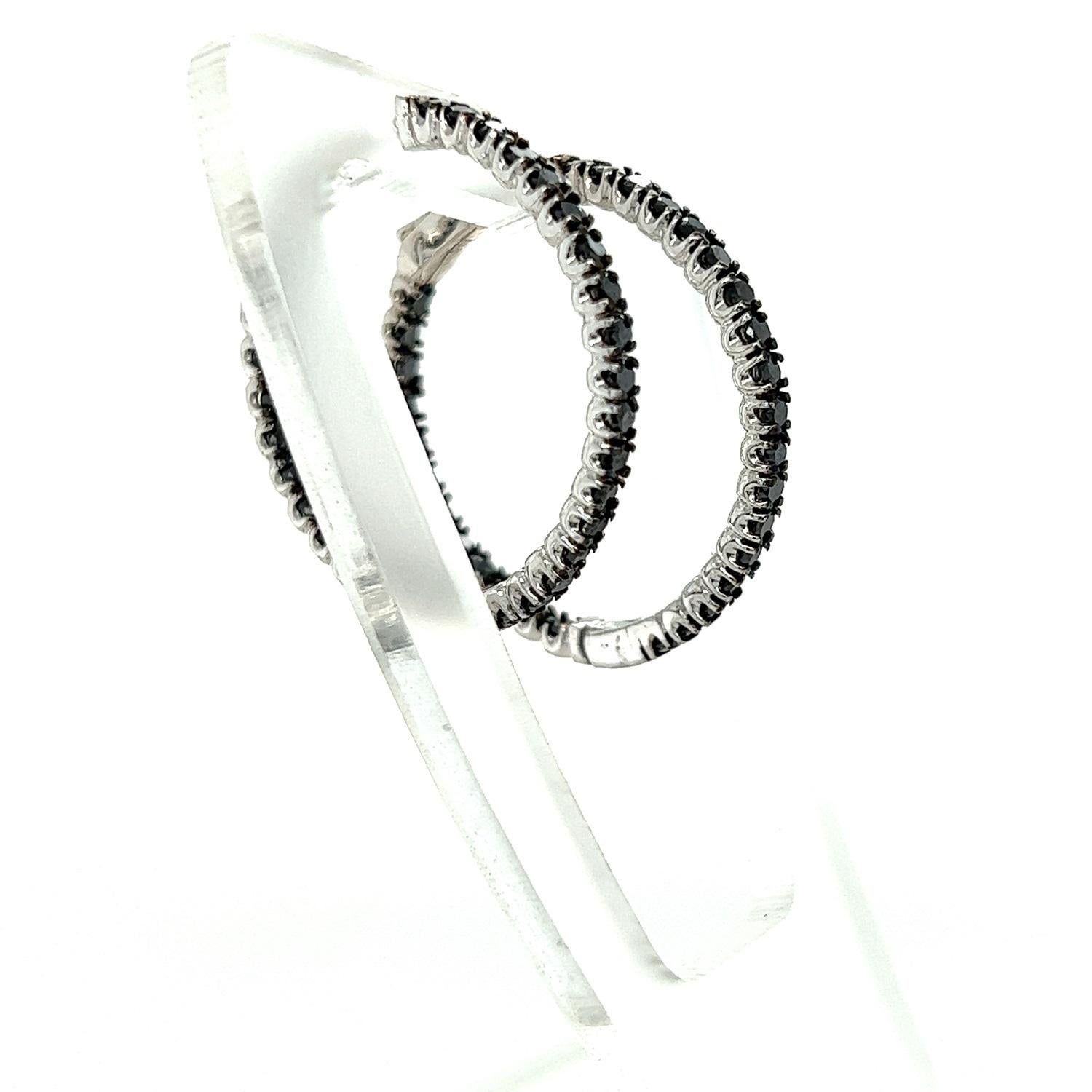 These hoop earrings have Natural Round Cut Black Diamonds that weigh 1.73 carats. 

They are set in 14 Karat White Gold and have an approximate gold weight of 5.8 grams.

The hoops are approximately 1 inches wide. 