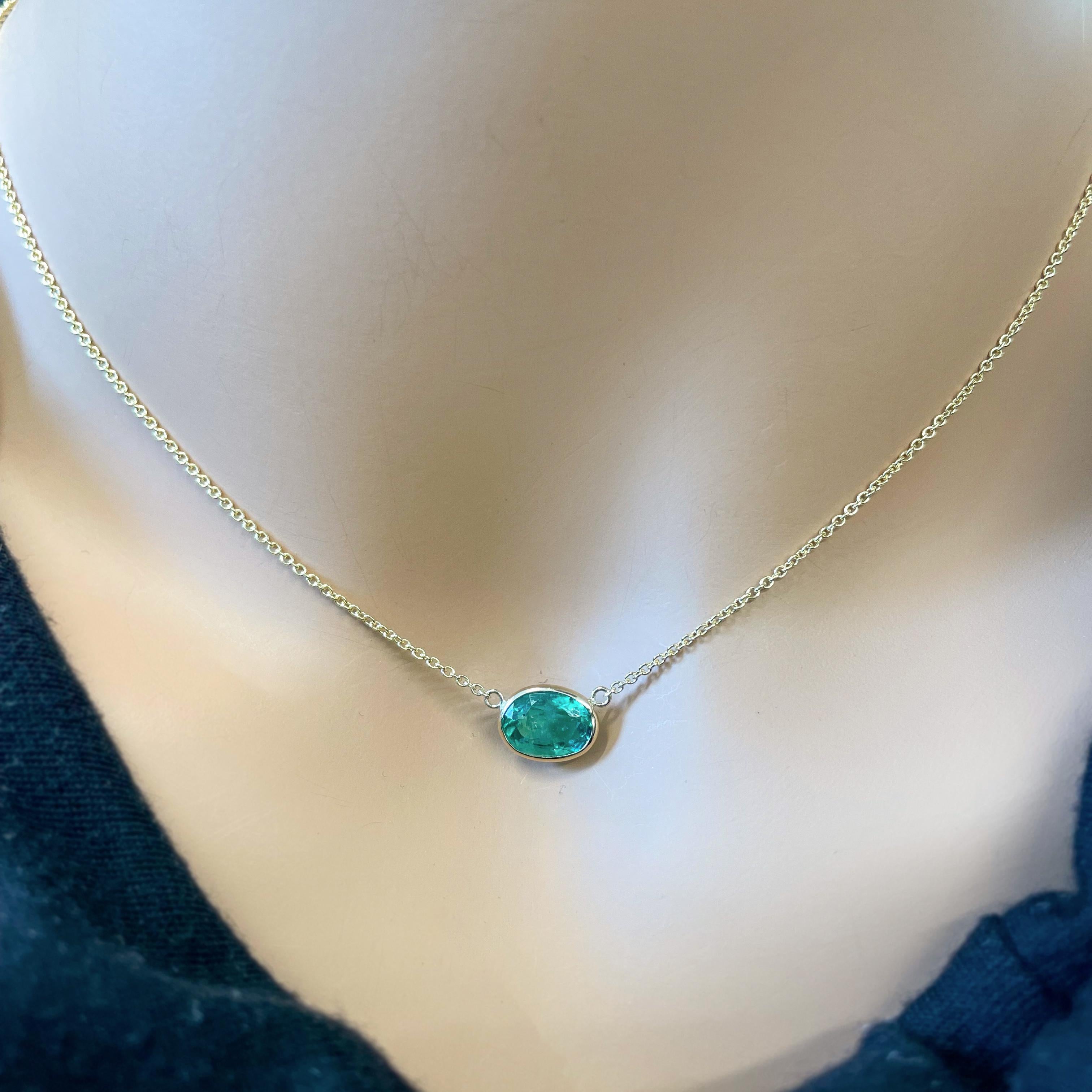 This necklace features an oval-cut green emerald with a weight of 1.73 carats, set in 14k yellow gold (YG). Emeralds are prized for their vibrant and rich green color, and the oval cut is a classic choice for gemstones, offering an elegant and