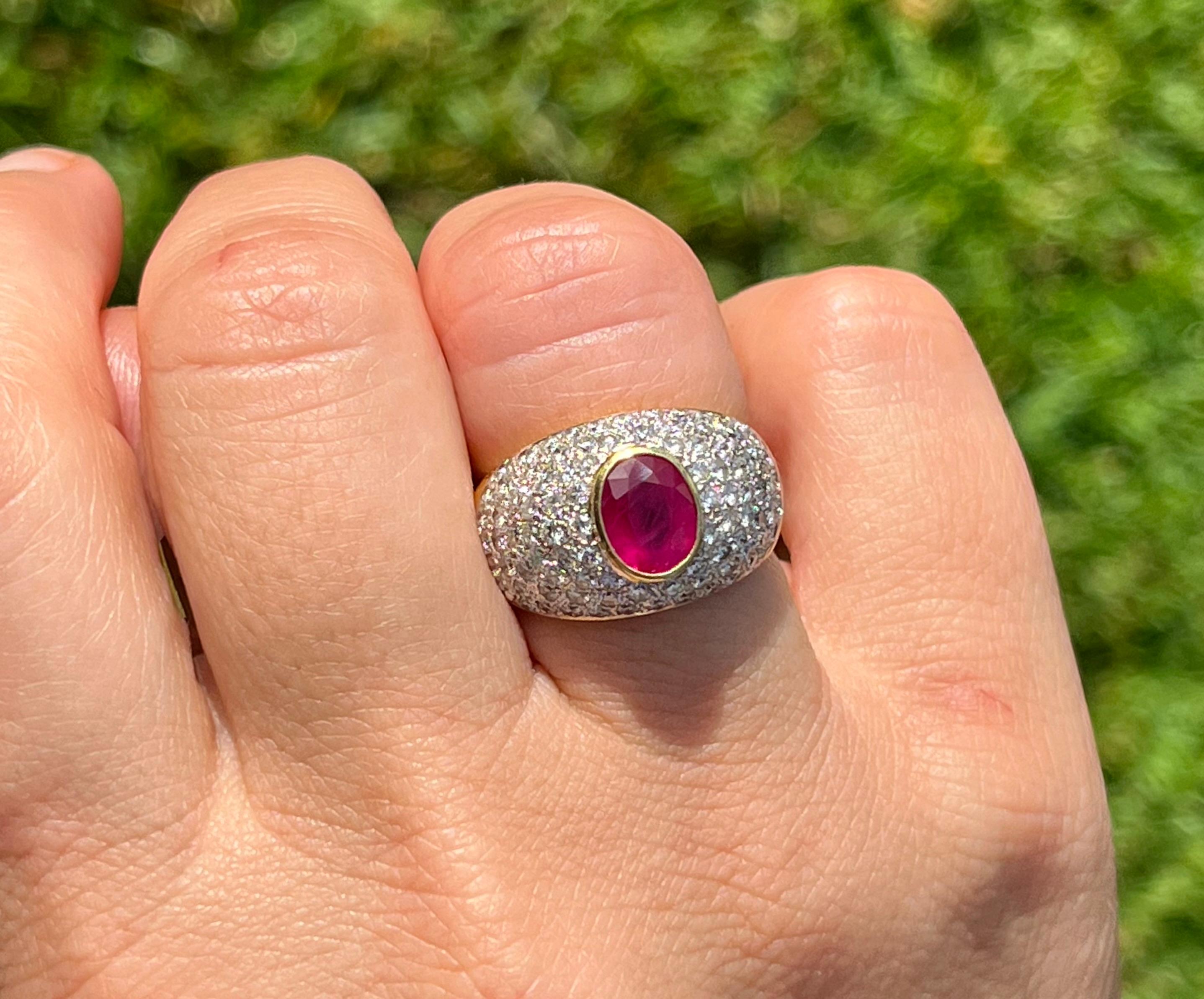 Red and robust, this natural Ruby ring is a classic cocktail ring with Art Deco inspirations. The Ruby is mounted in a secure bezel setting of 18 karat solid yellow gold with a double rhodium-plated white gold overtone where the diamonds set.