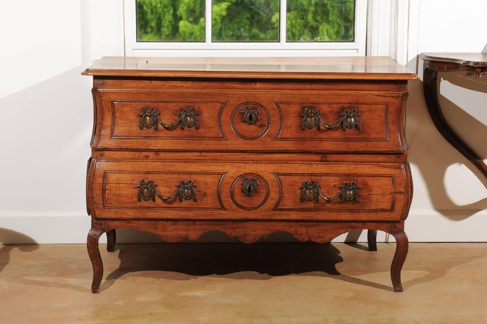 A French period Louis XV walnut two-drawer commode from the first half of the 18th century. Born in the early years of the reign of King Louis XV, This French walnut commode features a slightly raised rectangular top with rounded corners and