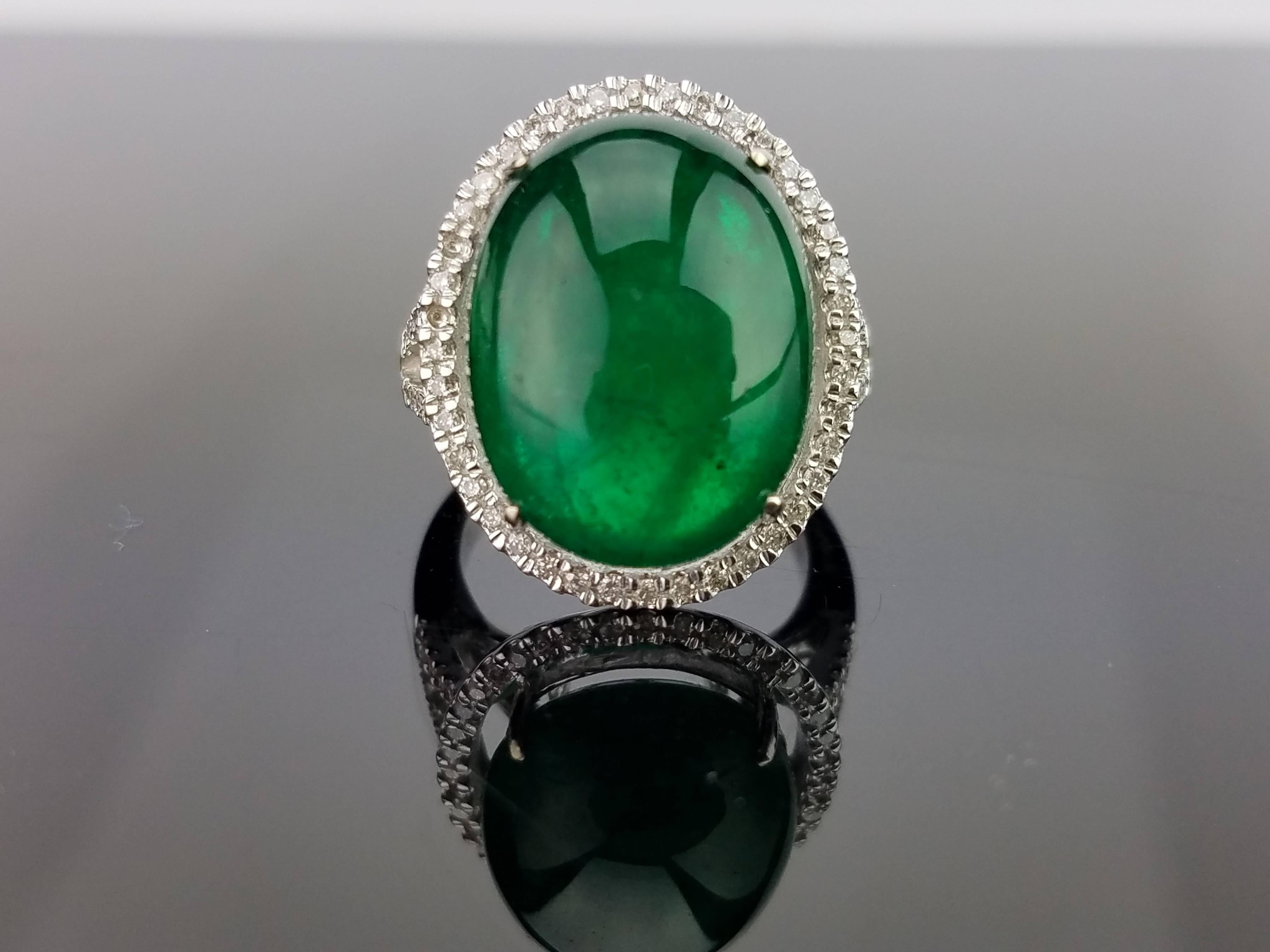 A statement Emerald cabochon cocktail ring sorrounded with diamonds, all set in 18K gold band. 

Stone Details: 
Stone: Zambian Emerald
Carat Weight: 17.35 Carats

Diamond Details: 
Total Carat Weight: 0.4 carat
Quality: VS/SI , H/I

18K Gold: 7.69