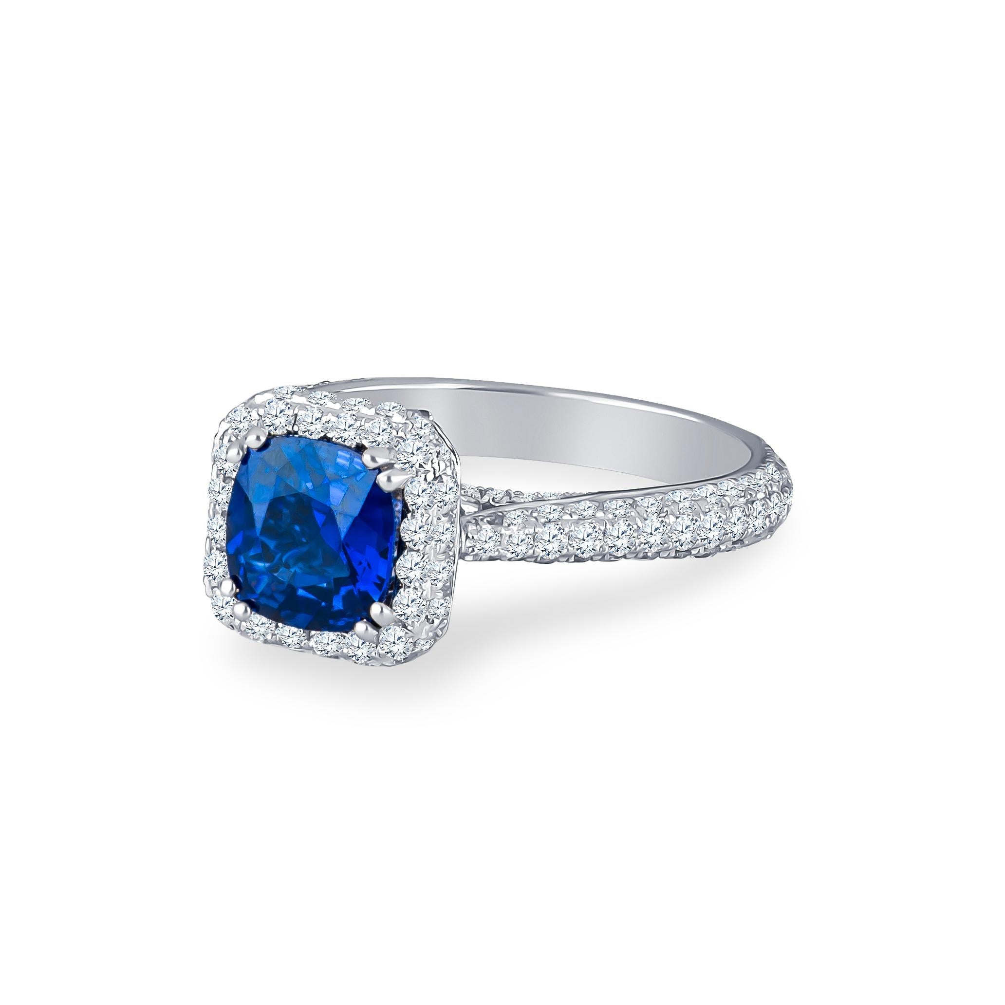 1.74 Carat cushion cut very fine royal blue Ceylon sapphire (GIA report) with 1.30 carats total in micropave round brilliant diamonds. Set in an 18 Karat white gold, diamond halo ring. Ring size 7, size is adjustable to larger or smaller upon
