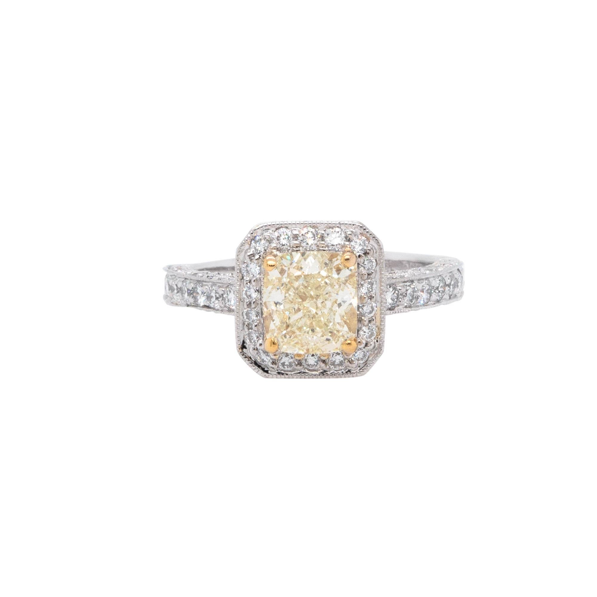 This is a ring that features a 1.74ct natural cushion cut diamond in a fancy yellow color with a diamond halo. It is made of platinum and 18k yellow gold and has 1.00ctw of round cut natural diamonds with G/H color and VS clarity. The ring comes in