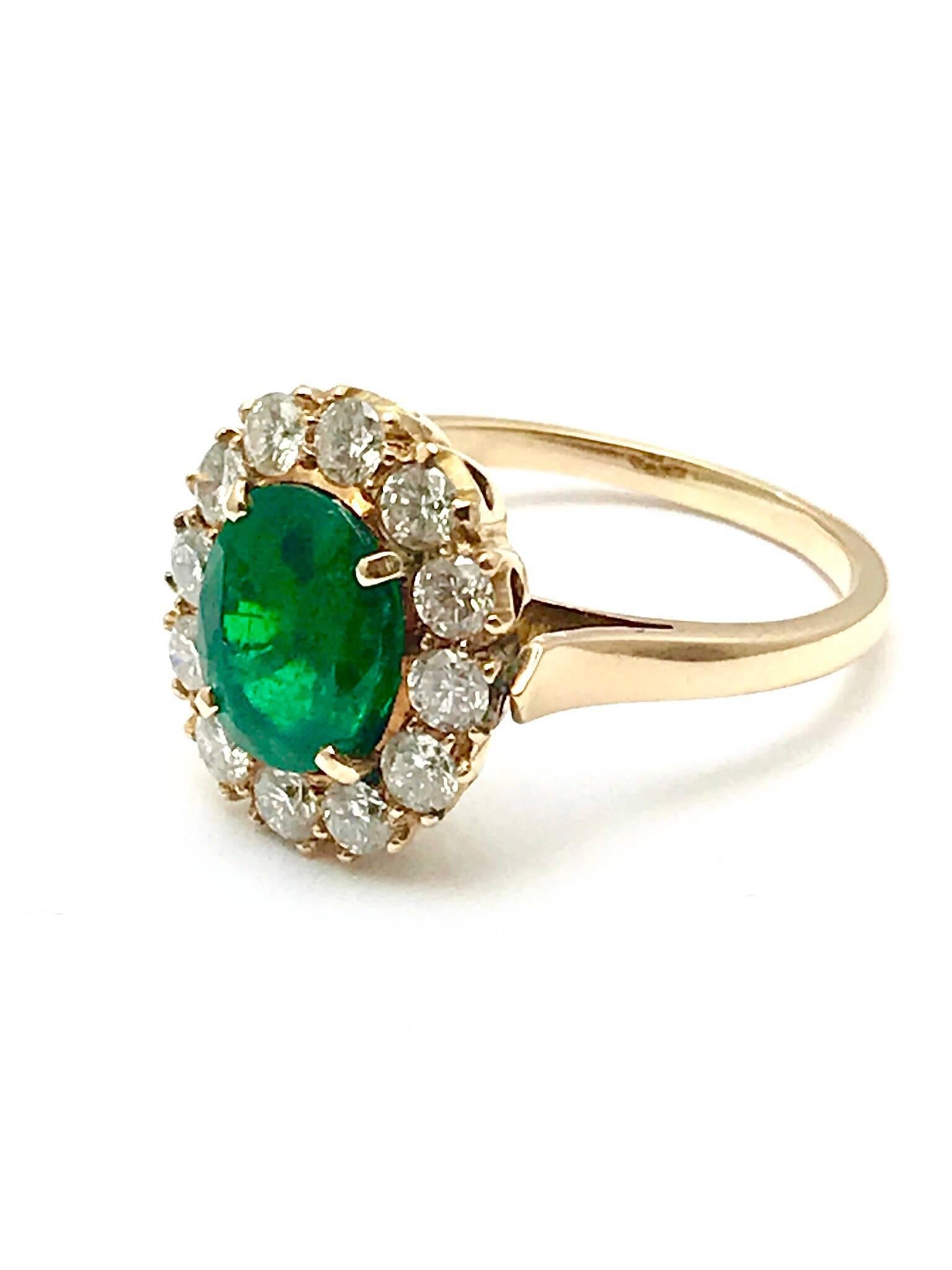 A 1.74 carat natural oval emerald and round diamond 14 karat rose gold ring.  The vibrant emerald is prong set, framed by a single row of round brilliant cut diamonds, graded as G-H color, SI clarity, weighing 1.20 carats total.  The shank of the