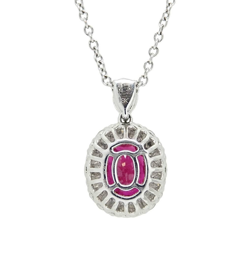 This Classic 18K White Gold Necklace With A Breathtaking Oval Cut Ruby Weighing A Total Carat Weight Of 1.74 Carats. Round Diamonds Sparkle As They Outline The Center Ruby and Weigh A Total Carat Weight Of .92 Carats.