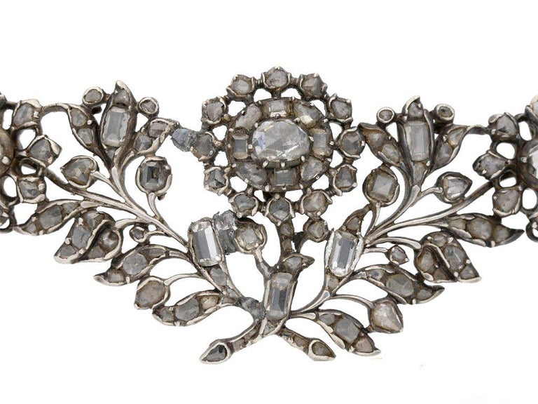 Georgian diamond brooch. Set with one hundred and ten rose and table cut diamonds of varying shapes and sizes, in closed back cut down settings with a total approximate diamond weight of 10.00 carats, to an elegantly articulated openwork design,