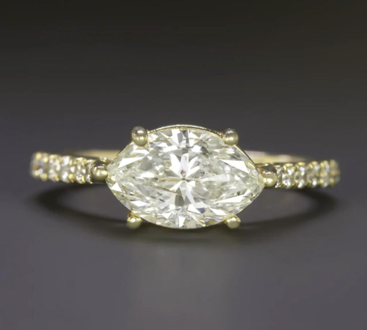 Cette magnifique bague en diamant taille marquise met en valeur un diamant naturel de 1,74 ct serti dans une orientation est-ouest élégante, mettant en valeur son attrait moderne et élégant. La fine tige incrustée de diamants ajoute une touche
