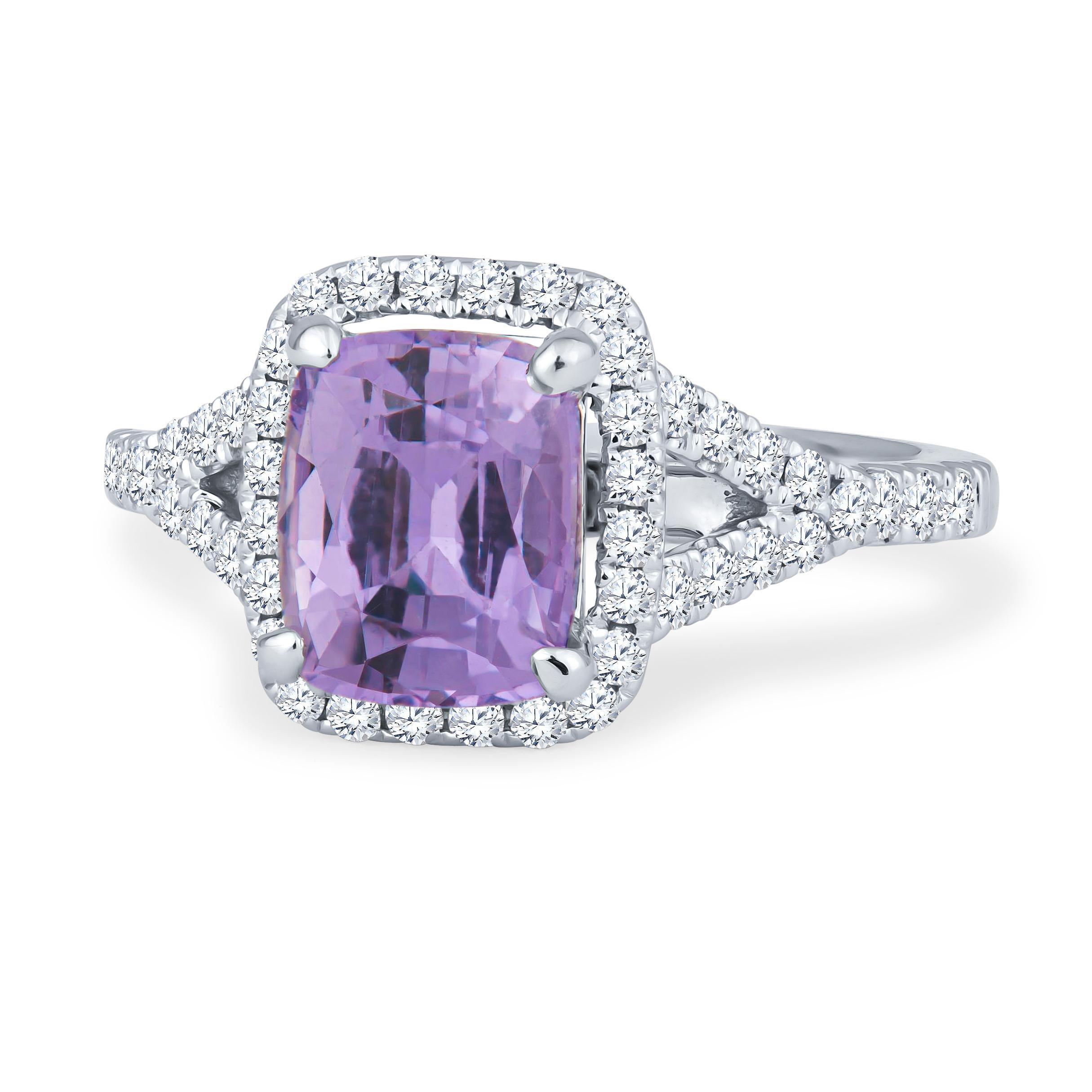 This insanely beautiful 1.74ct cushion cut natural sapphire is a purple hue that has not been heat treated and is noticeable from a mile away. This vibrant stone is set in an 18kt white gold cushion halo split shank ring and is surrounded by 0.45ct