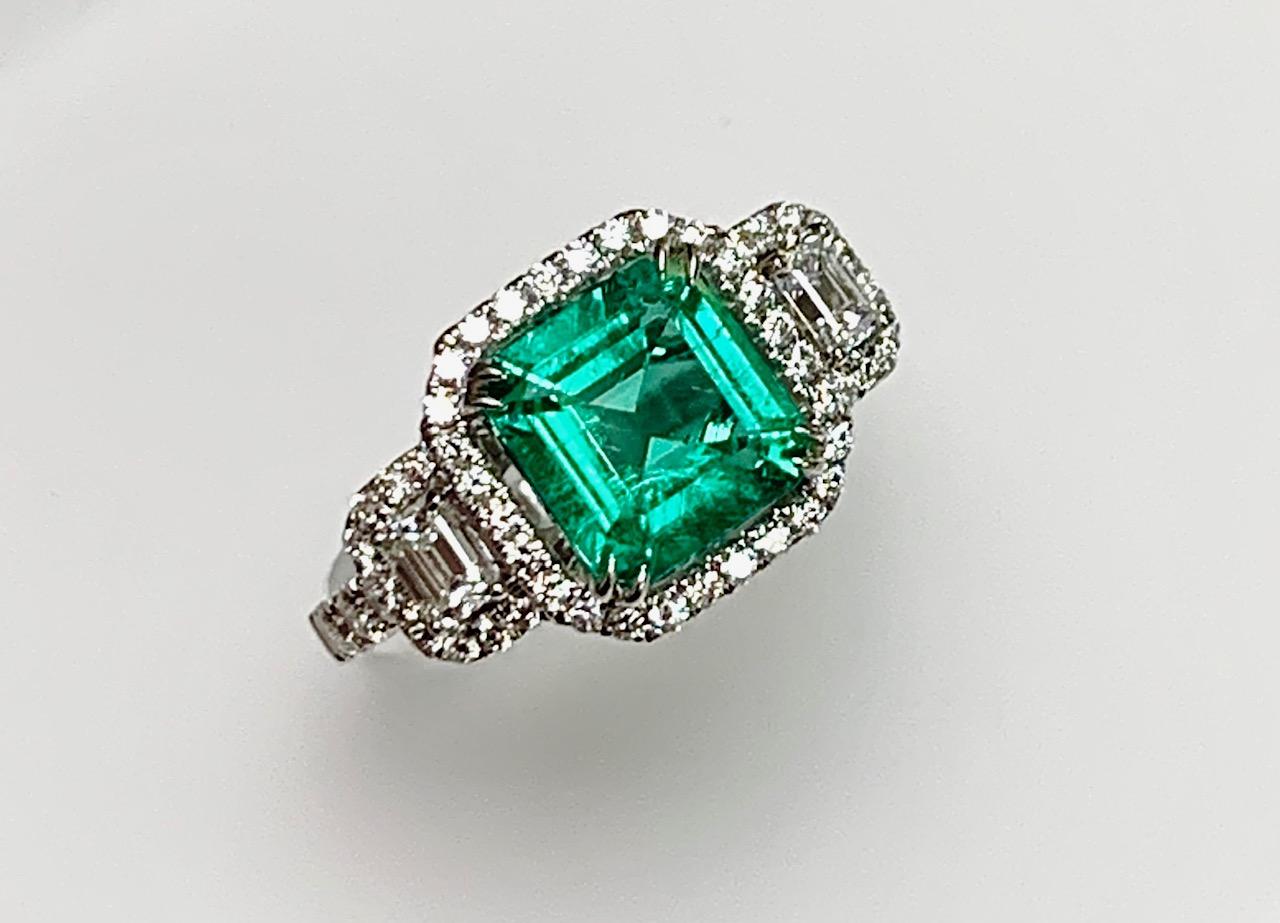 1.75 Carat Square shape Colombian emerald set in 18k white gold ring three stone style with 2 emerald cut Daimonds and round diamonds around and hlaf way on the shank totaling 0.83 carat .