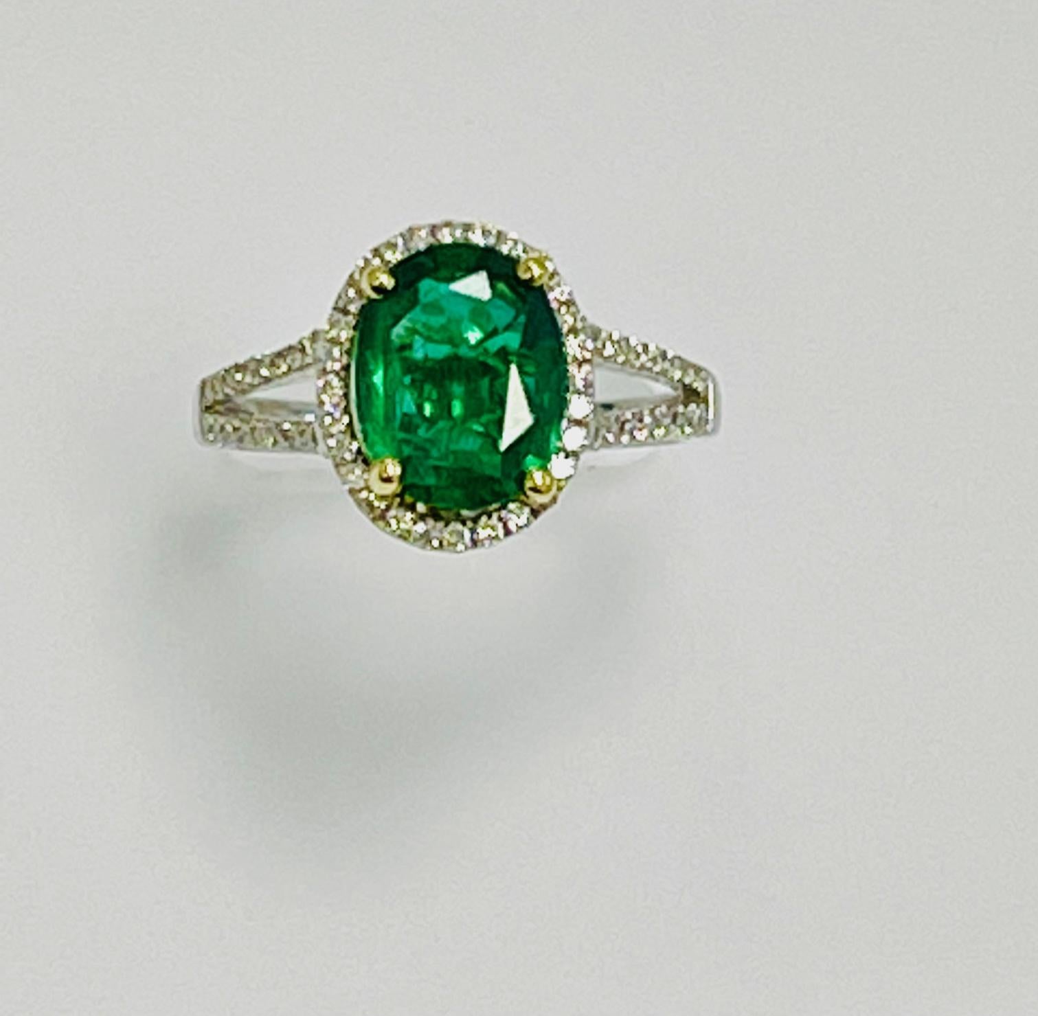 1.75 Carat Oval shape zambian emerald set in 18k white gold ring with   0.42 carat   diamonds  around it and half way on the split shank .
