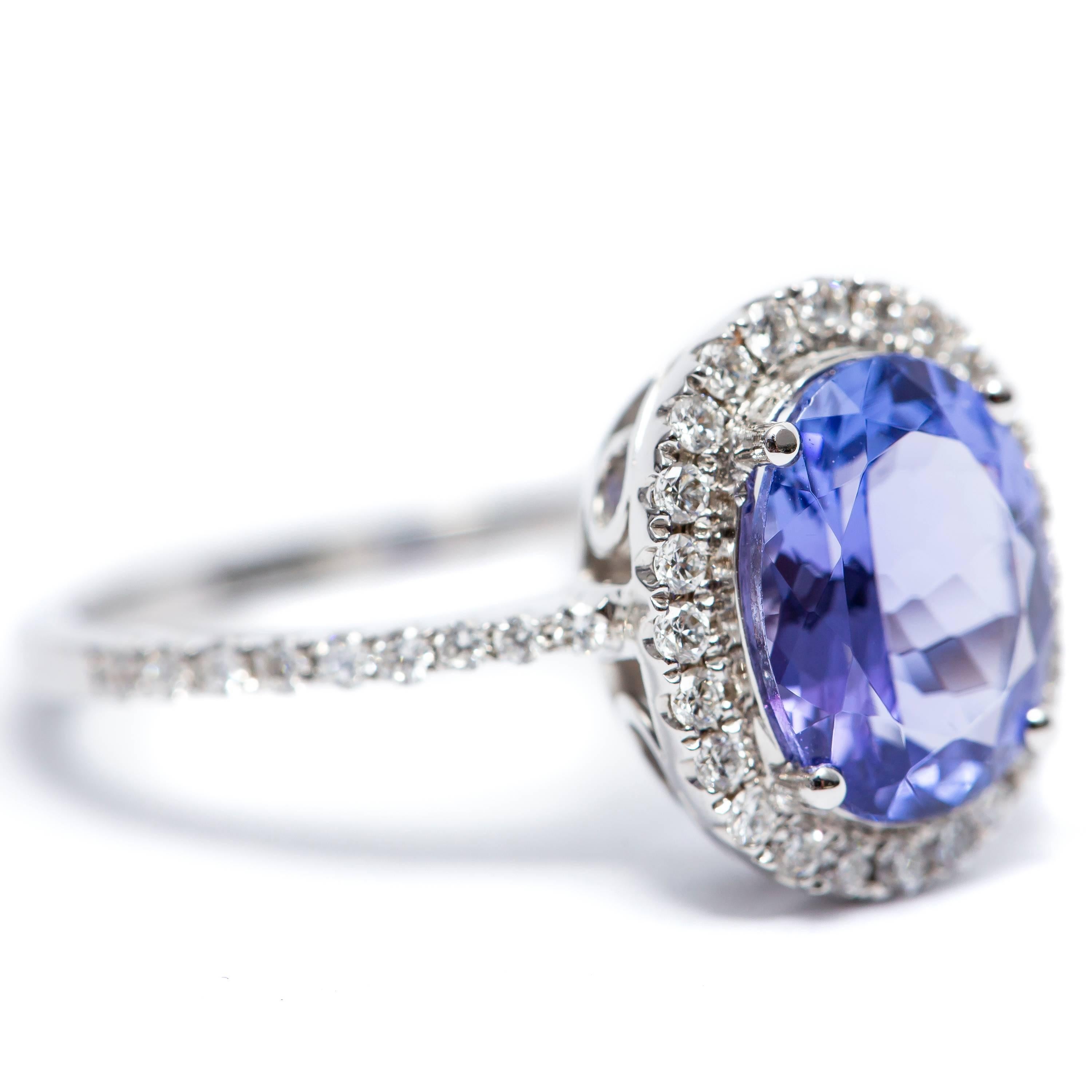 Elegant and beautiful with a total of 2.03 carat of gemstones,  1.75 Carat oval-shaped tanzanite in a halo design with round brilliant cut diamonds totalling 0.30 Carats White Color G/H Clarity SI. Set in 18 Karat White Gold. UK size M, USA size 6