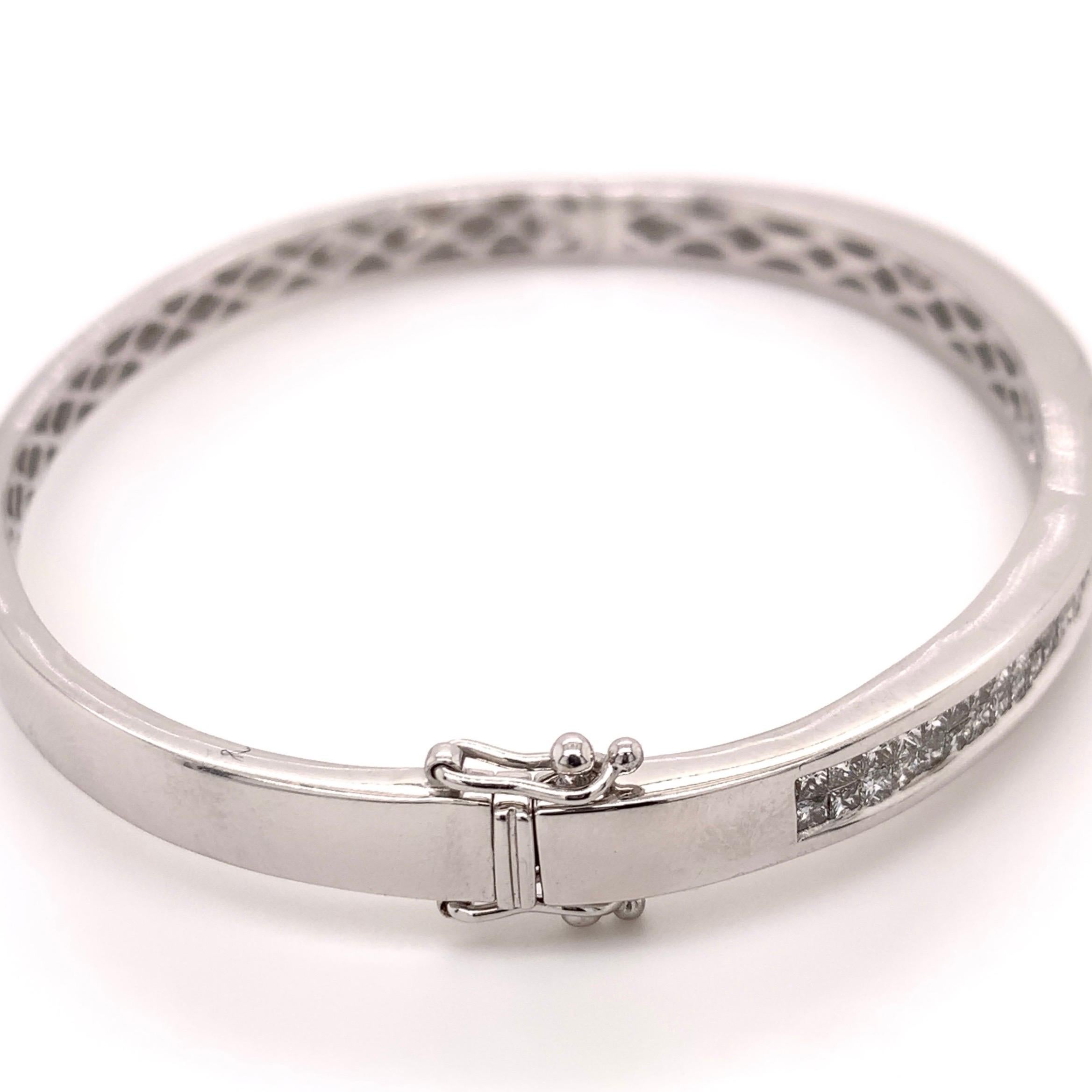 Classic white gold diamond bangle. Sparkling 1.75 carats princess cut diamonds mounted in an invisible setting. Handcrafted two rows of cluster design bangle bracelet set in high polished 14 karats white gold with push box lock and two safety