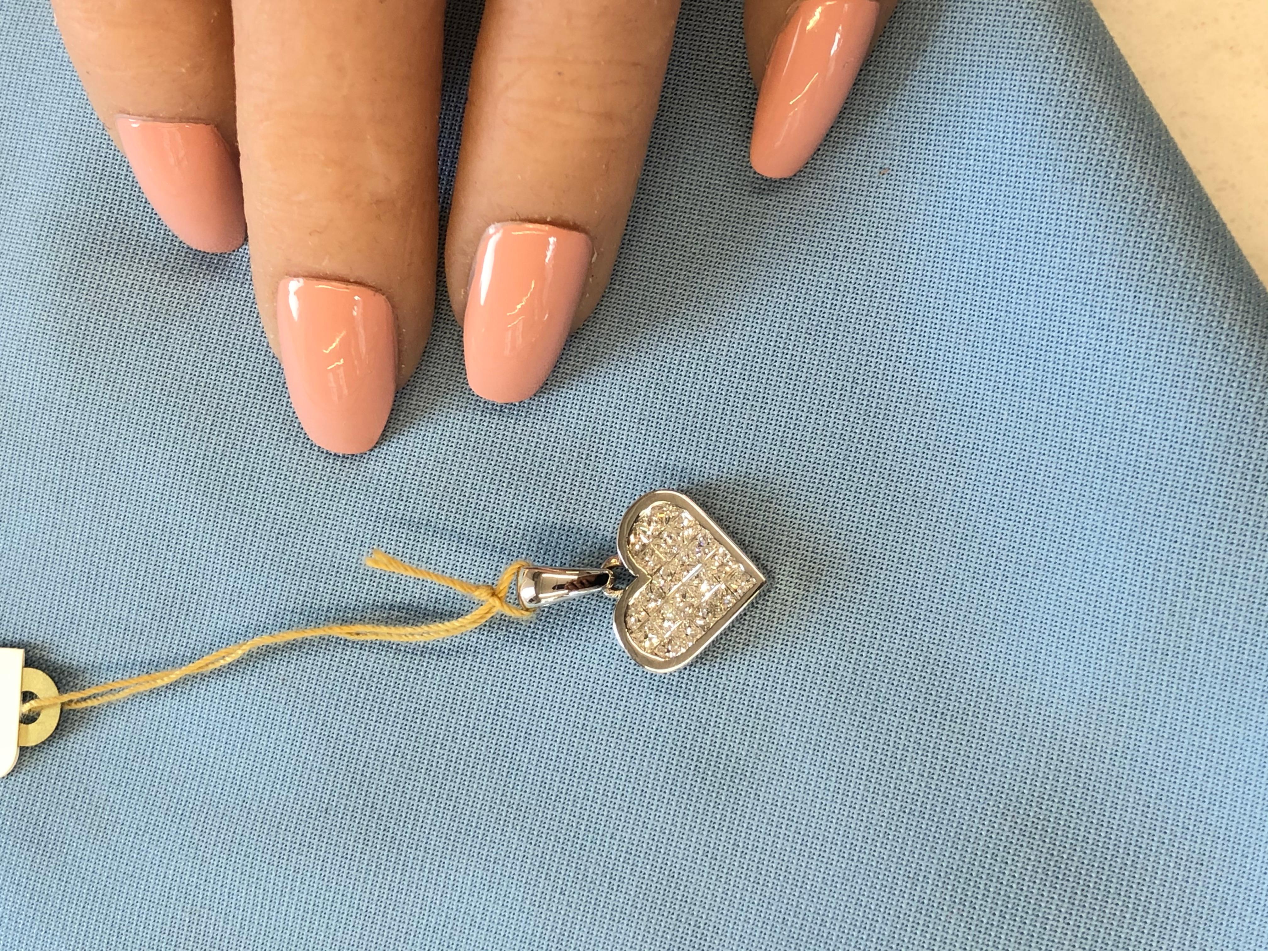 This gorgeous diamond heart pendant is finely crafted in brightly polished 18 karat white gold and features a total of 1.75 carats, F color and VS clarity, of invisibly set princess cut diamonds that are beautifully  arranged in a stunning heart