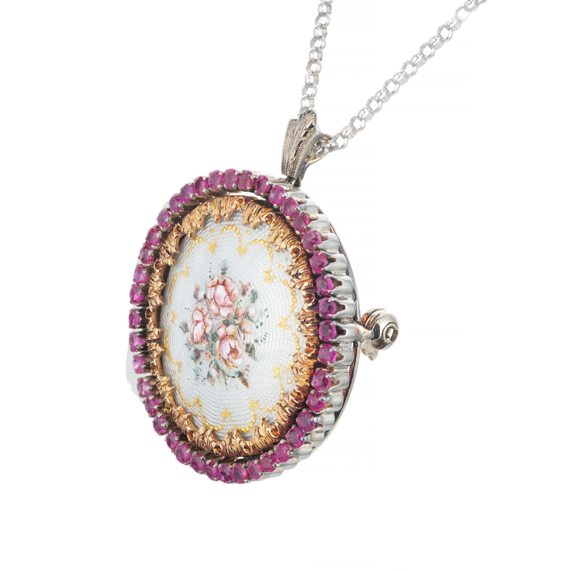 Handmade enamel flower circle Brooch pendant necklace with a halo of pink/red rubies, set in 18k yellow and white gold on a 16 inch chain. 

40 round pinkish red rubies, approx. 1.75cts
18k yellow gold 
18k white gold 
Stamped: 750
Top to bottom: