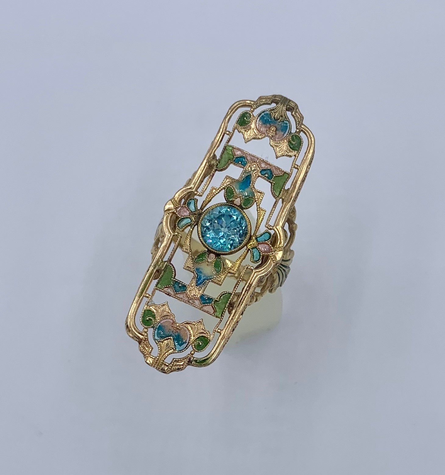 This is an extraordinary antique enamel ring with a stunning round faceted Zircon in the center.  The spectacular setting is adorned throughout with Plique a Jour Enamel decoration.  The Plique Enamel creates a stained glass effect of great beauty. 
