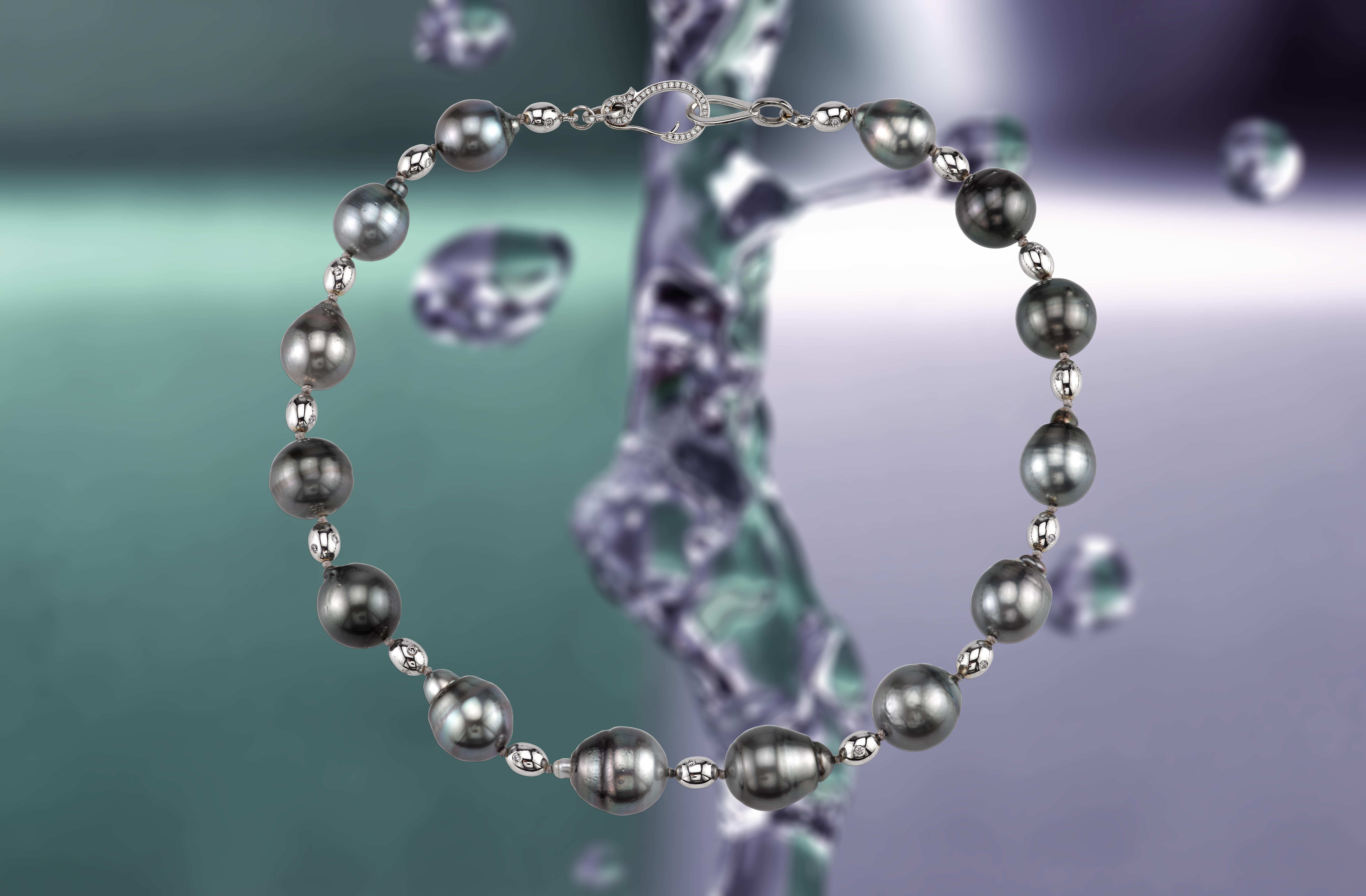 This 17.5-inch strand of natural Tahitian pearls is a work of art, hand-selected for their unique shape and iridescent color. The pearls are arranged to showcase their beauty and the hand-made white gold clasp adds a touch of elegance to the piece,