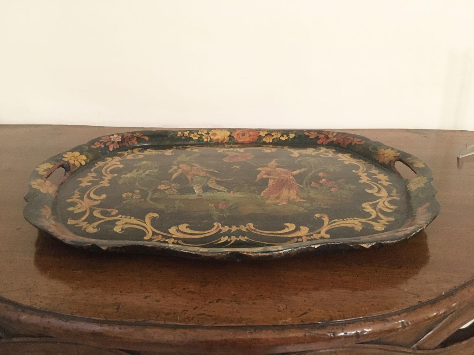 Dies ist eine große und exquisite lackierte Holztablett, mit floralen Dekoration und polychrome chinesische Figuren im Garten, auf einem grünen Hintergrund.
Die geschwungene Form des Tabletts, auf der  vorne und an den Seiten, sind das Ergebnis der