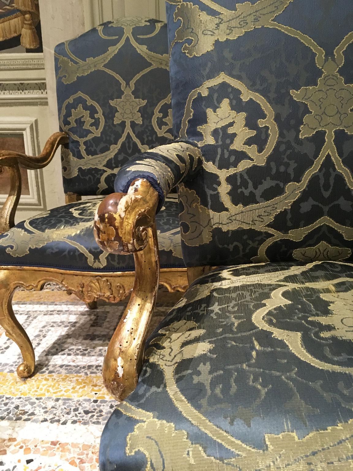 This is an exquisite gilded and carved pair of armchairs. The front and side parts are carved with scrolls that create a delicate carving effects. This pair hails from Mid- 18th Century, Venezia, Italy. These armchairs are the result of the high