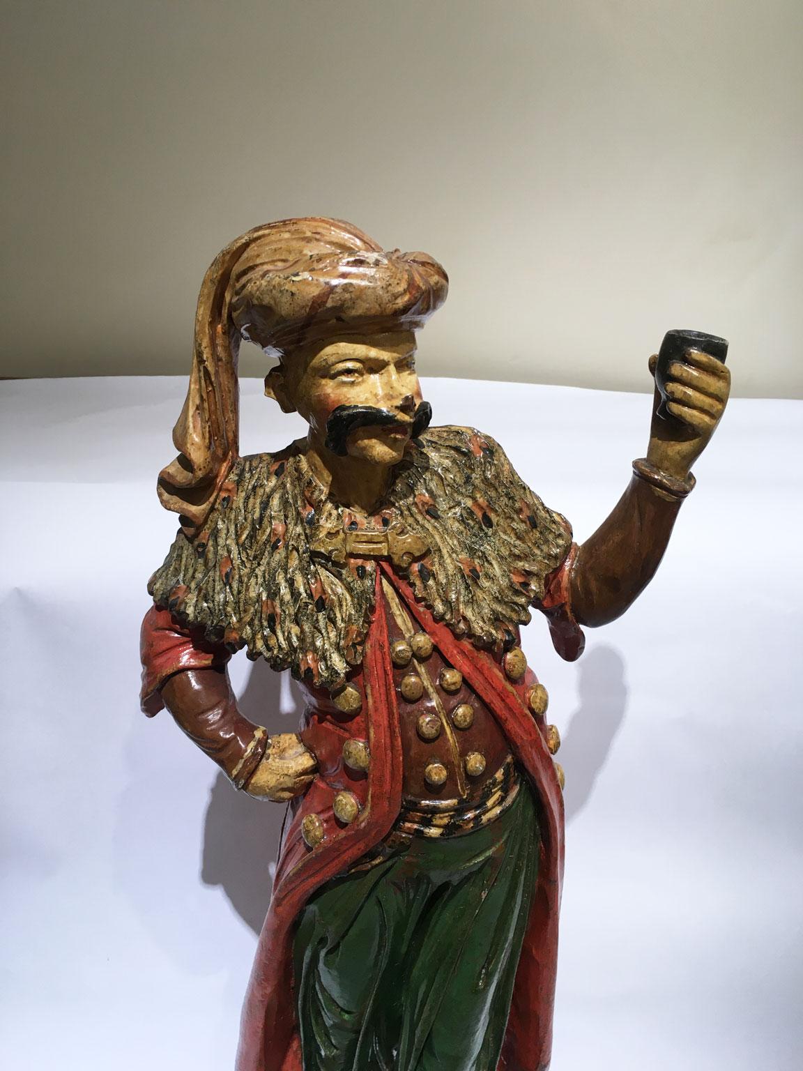 Se trata de una rara figura de hombre esculpida en madera tallada y lacada en policromía. Esta elegante pieza procede de mediados del siglo XVIII, de Venecia.
La forma curvada, tanto en el frontal como en los laterales, además de la exquisita