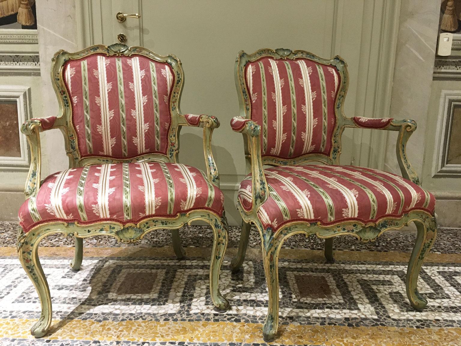 This is a magnificent set of two Venetian armchairs lacquered in light green with a fine polychrome little flowers decoration. 
The pieces have a delicate and refined drawing of polychrome floral garlands on the green background that enhances the