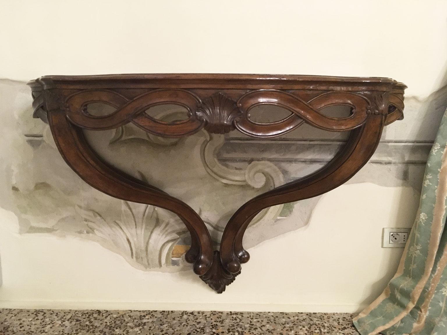 Esta refinada pieza muestra el exquisito gusto en la forma y el uso de los materiales, con nogal macizo de bello tono cálido que le da un aspecto elegante. La consola tiene una sensación de movimiento y fluidez en virtud de las bellas y