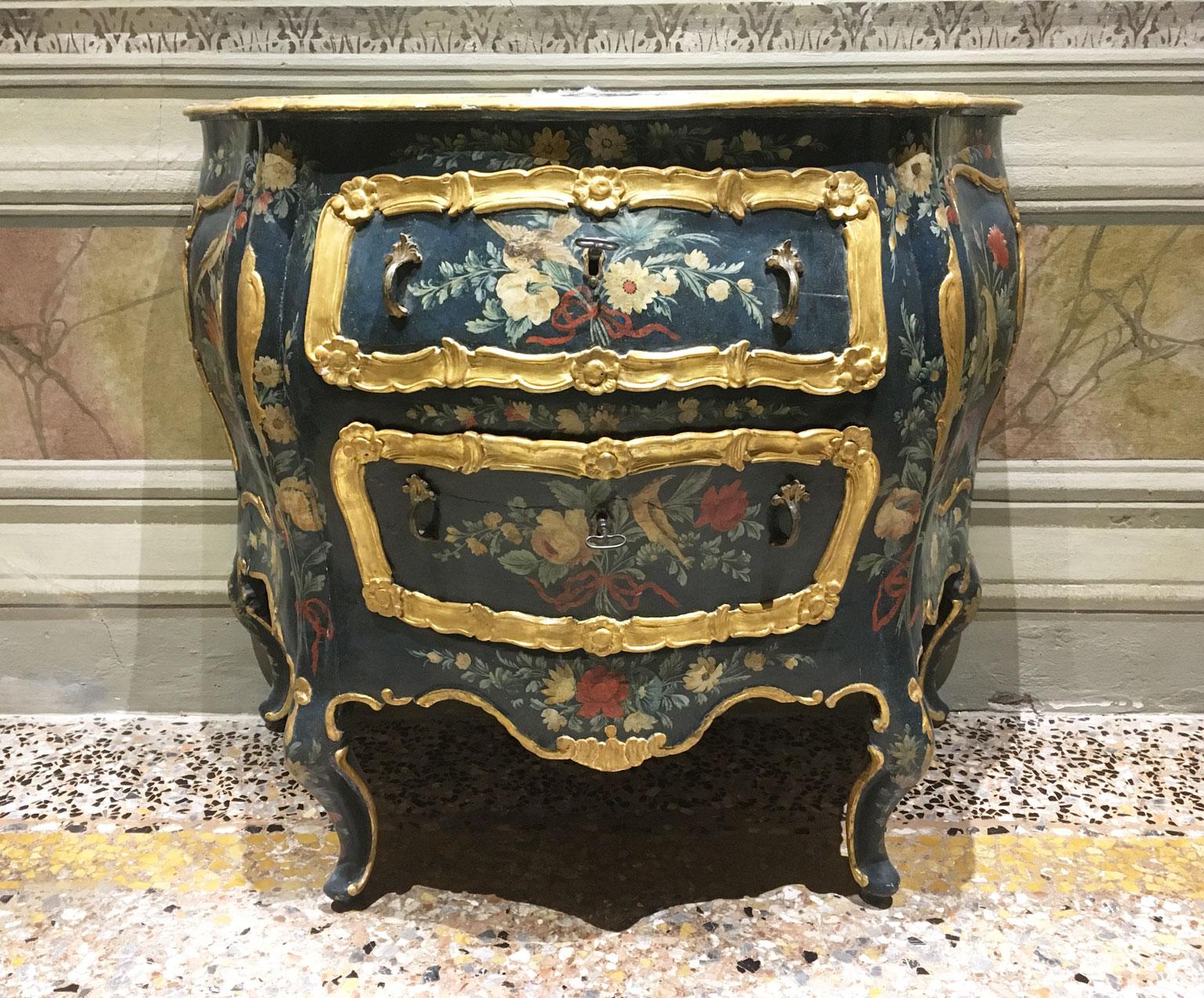 Dies ist eine außergewöhnliche  Venezianische Kommode aus lackiertem Holz mit polychromen Blumen und Fantasievögeln auf grünem Hintergrund.  Die Platte ist lackiert, um den Marmor zu imitieren. Die beiden Schubladen haben feine und geschwungene