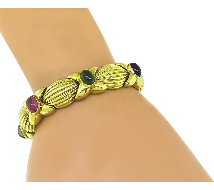 This is a stunning 18k yellow gold bracelet. The bracelet is set with lovely multi color gemstones that weigh approximately 17.50ct. These gemstones are green tourmaline, pink tourmaline, citrine, amethyst and peridot. The bracelet measures 7 inches