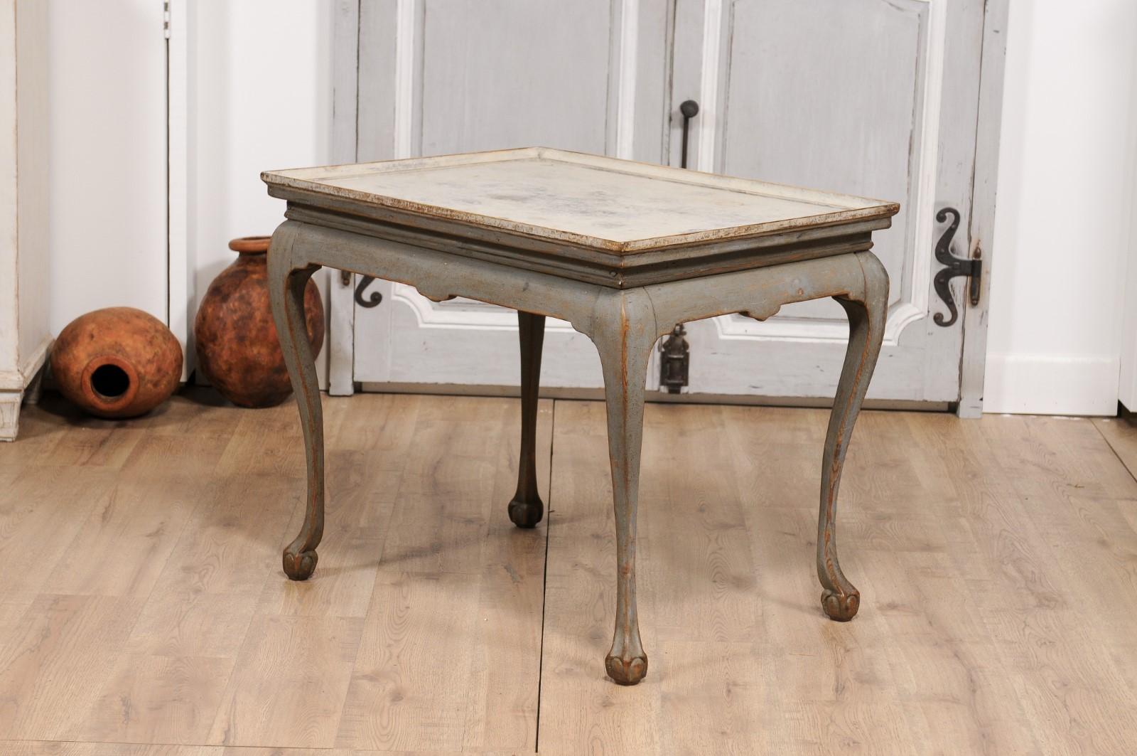 A Swedish Rococo period tea table from circa 1750 with gray painted finish, tray top, cabriole legs and ball and claw feet. Exuding timeless elegance, this Swedish Rococo period tea table from circa 1750 is an elegant testament to European