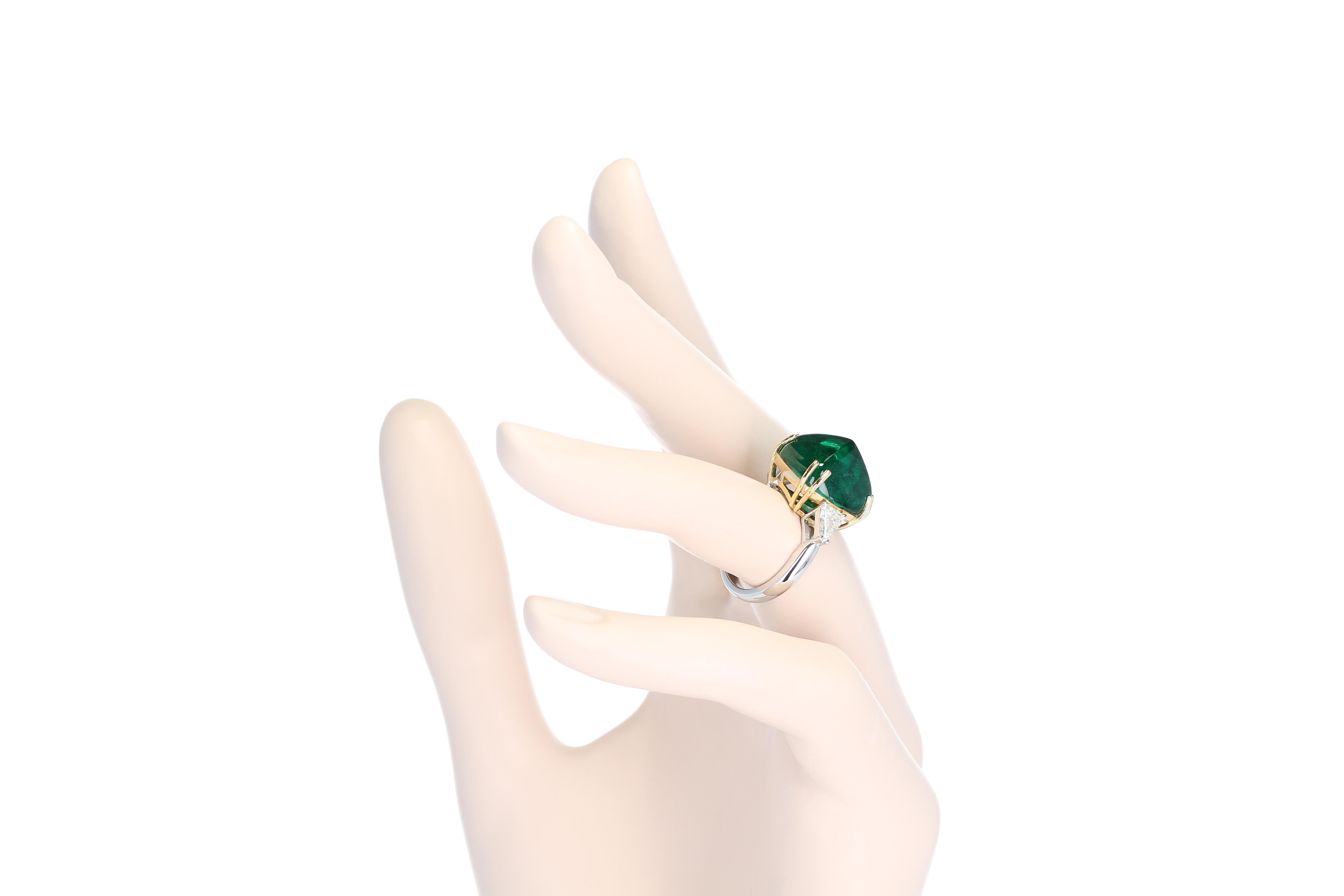 A stunning ring centered with a 17.53 carat Emerald Sugarloaf Cabochon, accented with two shield diamonds weighing approximately 0.68 carats total. The center emerald measures 14.87 x 14.83 x 11.34 mm and is accompanied by a gemological certificate