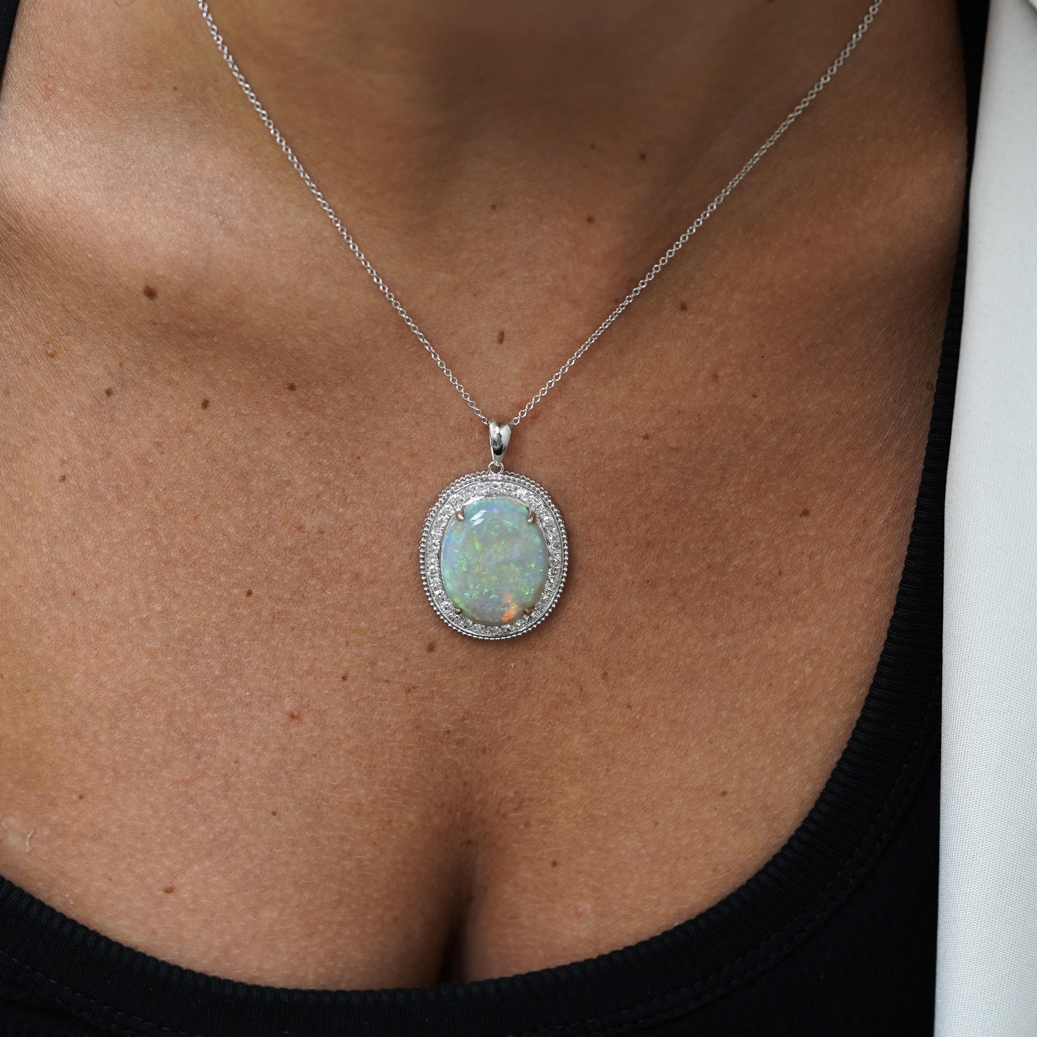 Pendentif en or blanc 18 carats composé d'une opale blanche naturelle de 17,59 carats et de diamants taille unique de 1,06 carat en serti halo avec détail de milgrain. L'opale aux couleurs spectaculaires mesure 22,7 x 18,3 mm dans un pendentif de