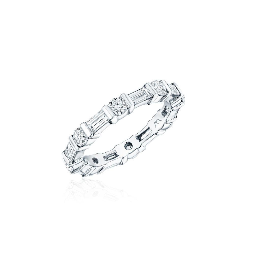 • Crafted in 18KT gold, this eternity band is made of a combination of 16 alternating round and baguette diamonds with a combining total weight of approximately 1.75 carats. The diamonds are set into a bar set eternity band. Worn beautifully on its