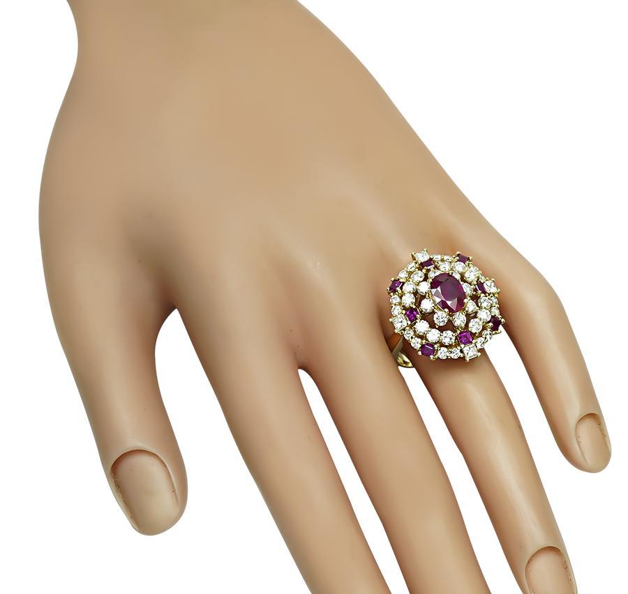 This is a gorgeous 14k yellow gold ring. The ring is centered with a lovely oval cut Burma ruby that weighs approximately 1.75ct. The center stone is accentuated by sparkling round and princess cut diamonds that weigh approximately 2.00ct. The color
