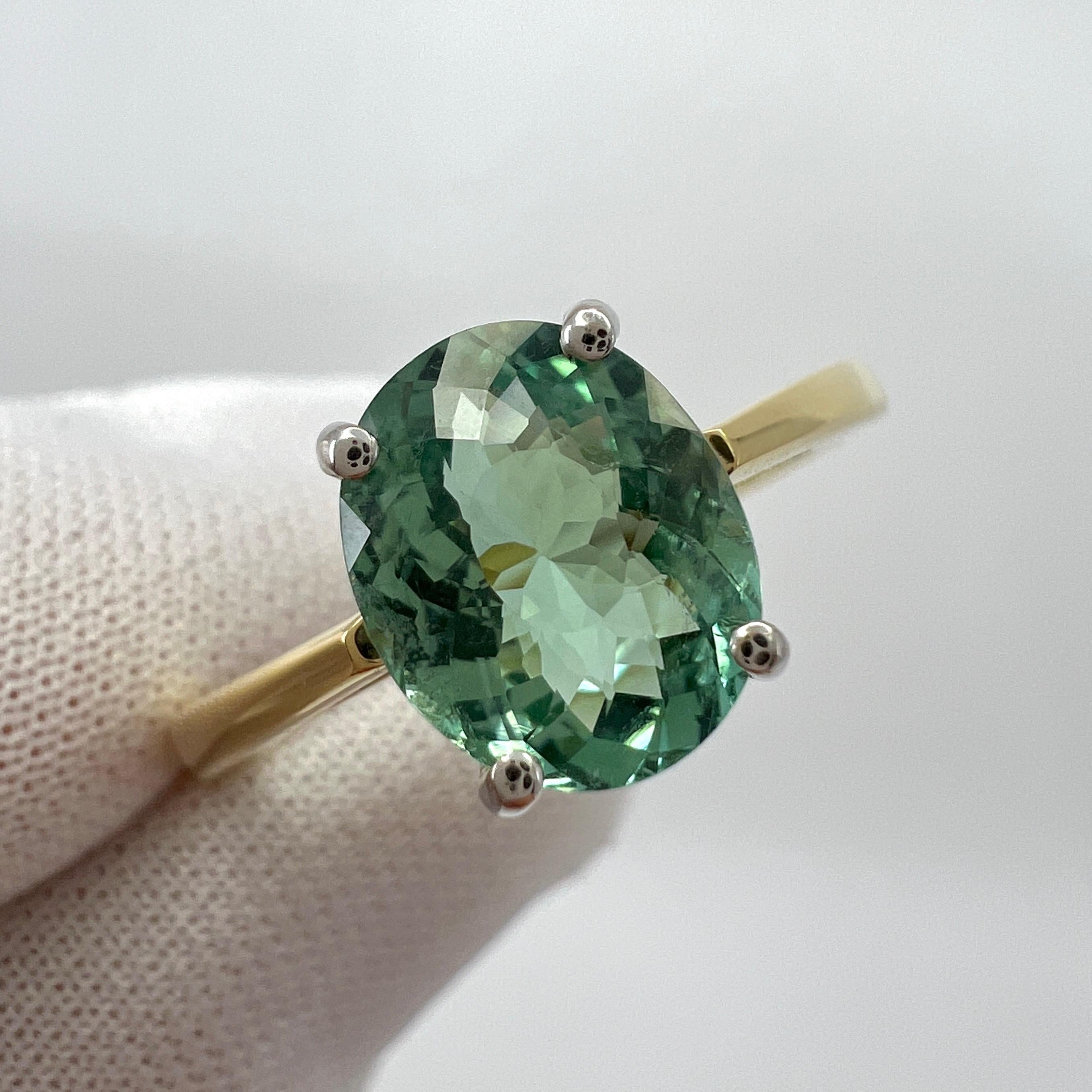 Vivid Blue Green Tourmaline Oval Cut 18k Yellow And White Gold Solitaire Ring.

1.75 Carat tourmaline with a stunning vivid green blue colour and good clarity. Very clean stone, with only some small natural inclusions visible when looking closely.