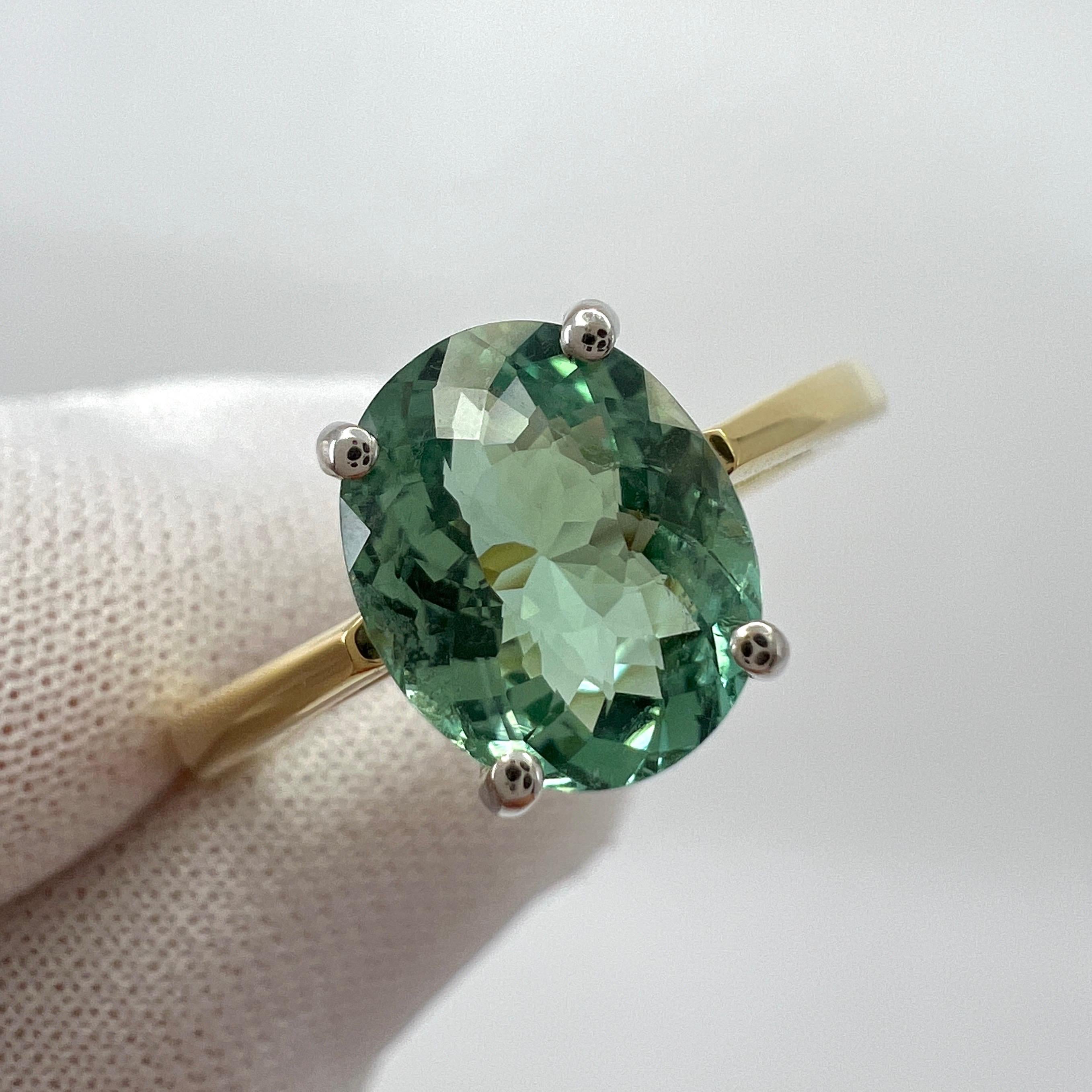 Lebendiger blaugrüner Turmalin Ovalschliff 18k Gelb- und Weißgold Solitärring.

1,75 Karat Turmalin mit einer atemberaubenden lebhaft grünblauen Farbe und guter Reinheit. Sehr sauberer Stein, mit nur einigen kleinen natürlichen Einschlüssen, die bei