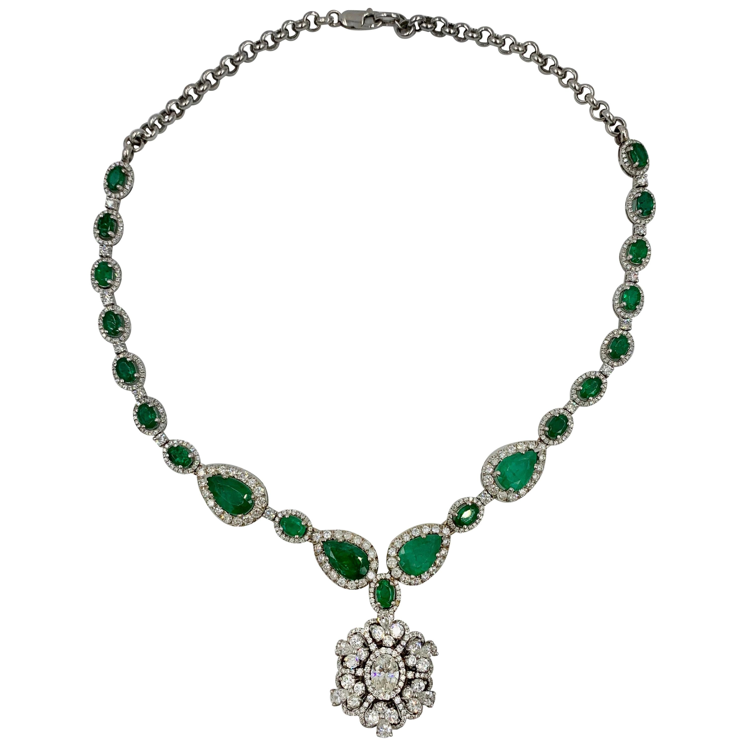 This is a spectacular Antique Estate Emerald and Diamond Pendant Statement Necklace of great beauty.   The dramatic necklace features a Diamond Pendant with a central oval Brilliant Cut Diamond of approximately 1 Carat.  The center Diamond is a