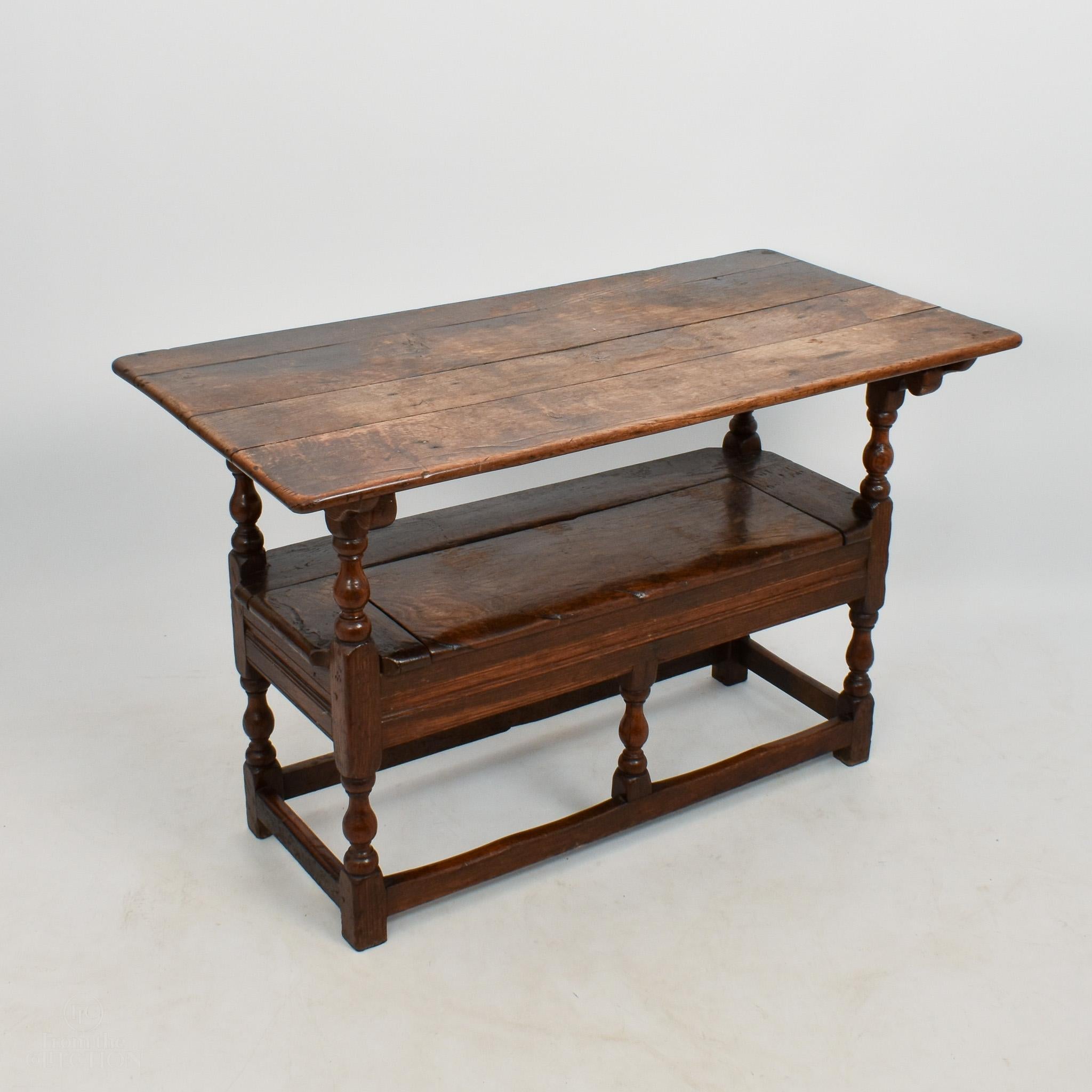 Oak circa 1760 Monk's bench that becomes a table. In original condition with beautiful colour. The seat lifts up for storage. With six turned legs and front and back joining railings. There are markings on the surface and bench that add a richness