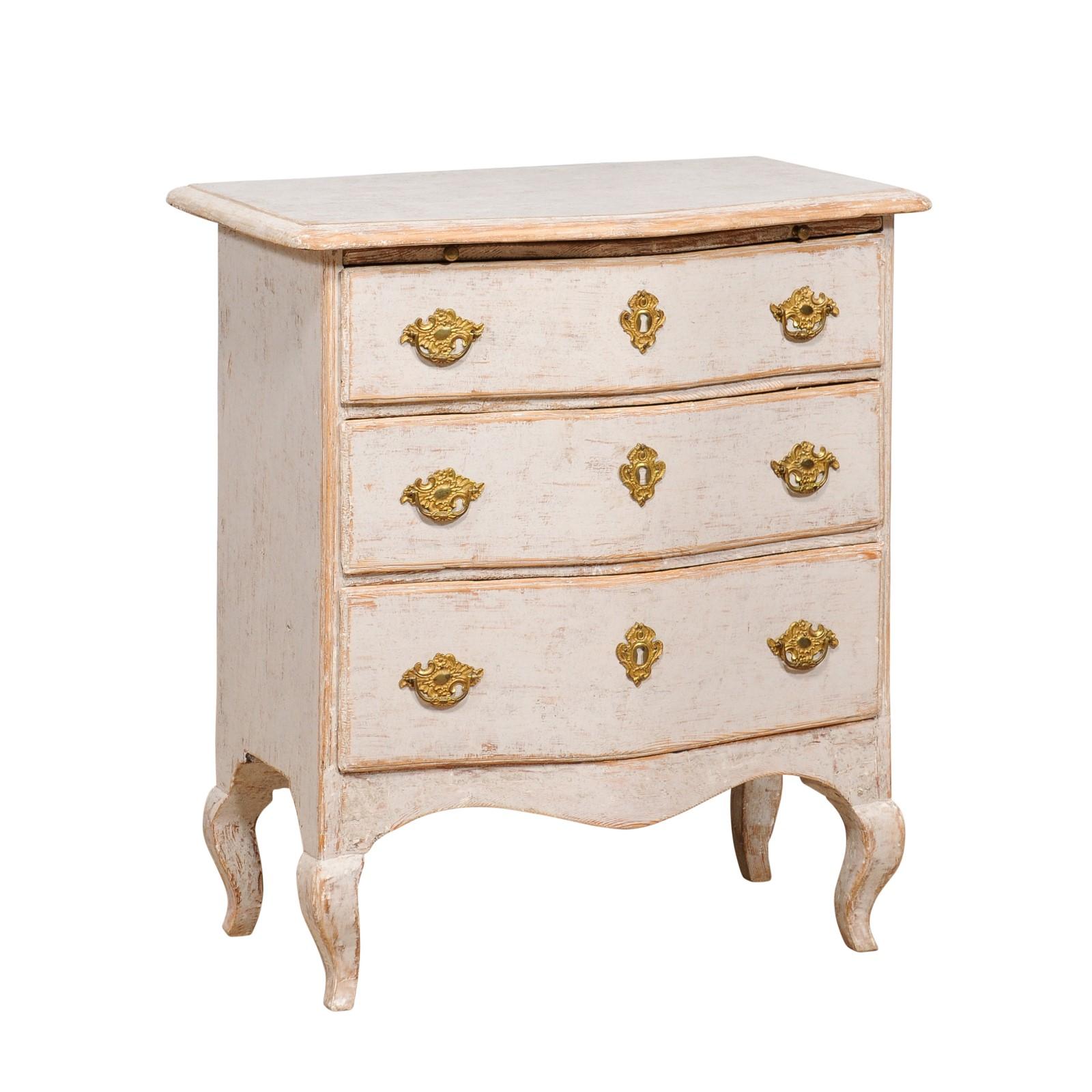 A Swedish Rococo period neutral light grey painted chest from circa 1760 with three drawers topped by a discreet pull-out, serpentine front, cabriole legs and ormolu hardware. Emanating the grace and nuanced elegance of the Swedish Rococo period,