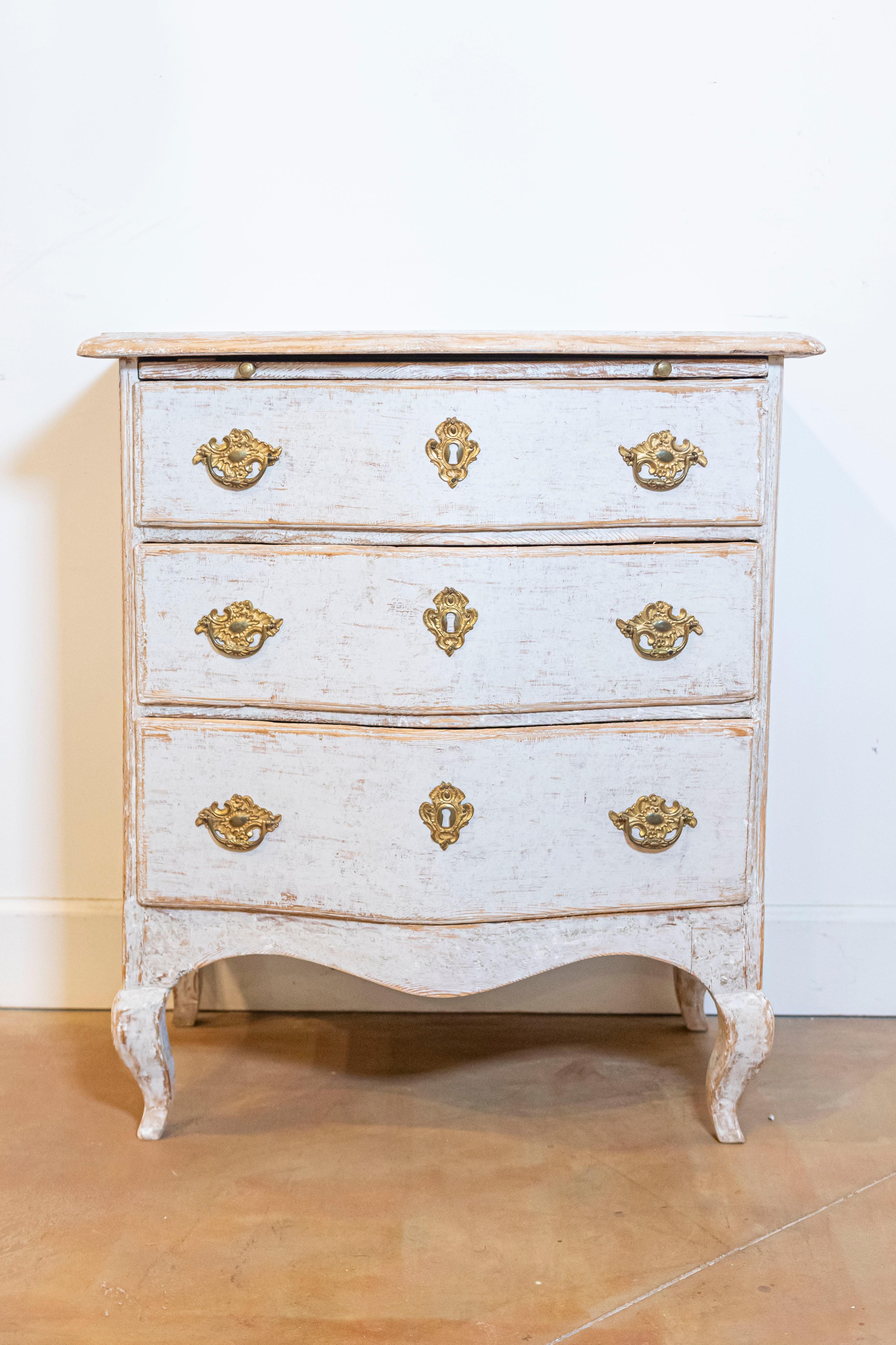 A Swedish Rococo period neutral light grey painted chest from circa 1760 with three drawers topped by a discreet pull-out, serpentine front, cabriole legs and ormolu hardware. Emanating the grace and nuanced elegance of the Swedish Rococo period,