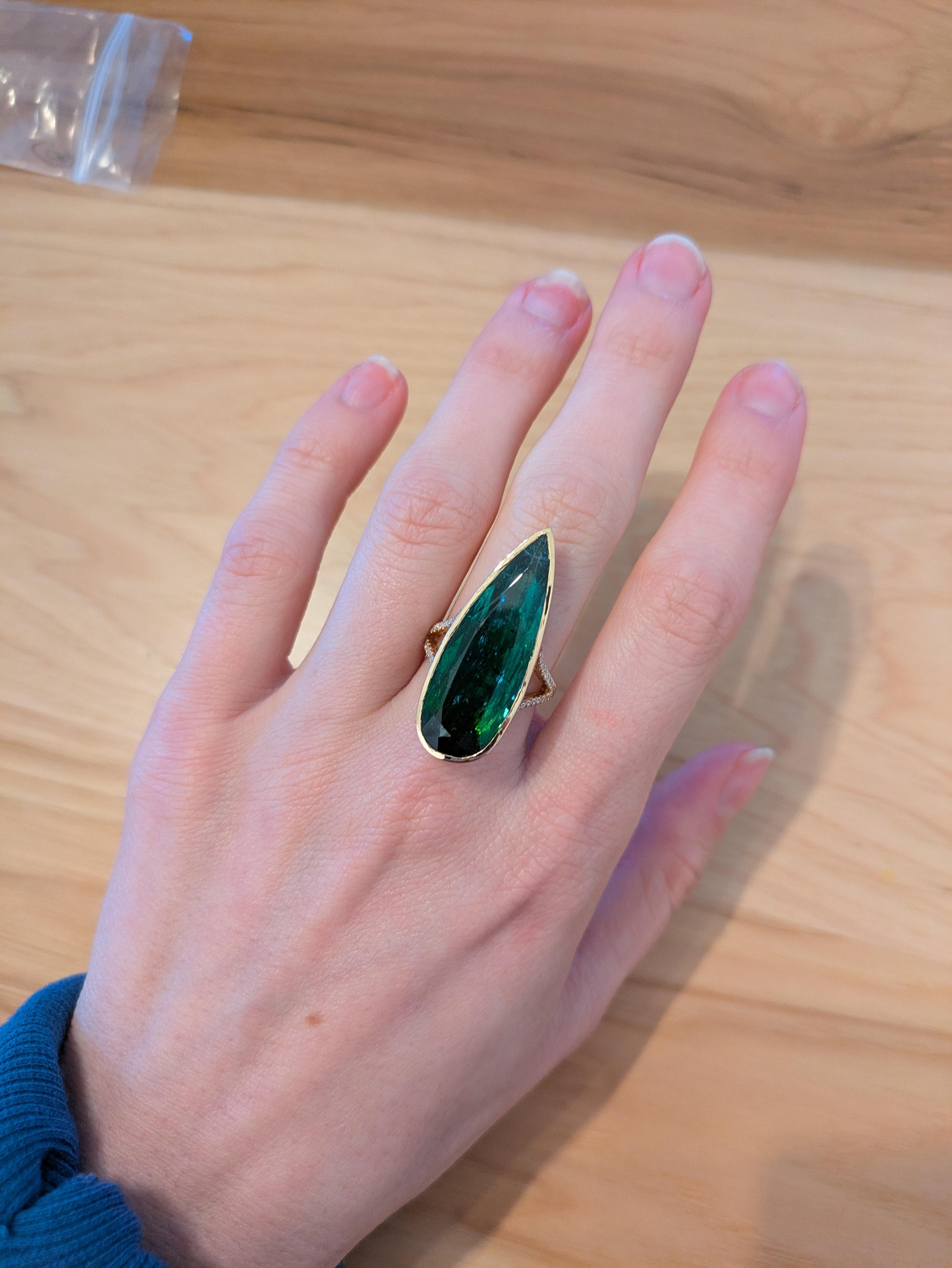 This statement 17.65-carat chrome tourmaline ring features a striking pear shape, set in solid 14k real gold. The pave diamond split shank, adorned with earth-mined diamonds, brings an extra layer of sparkle and elegance to the piece. With its large