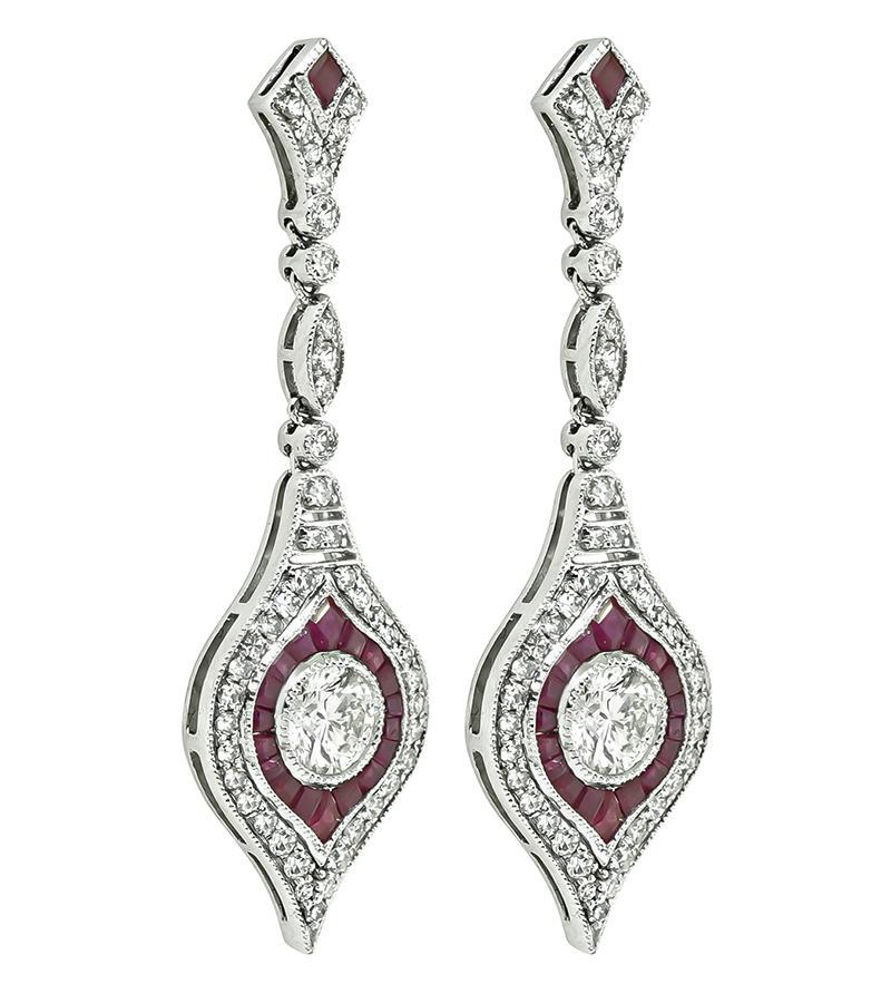Dies ist ein erstaunliches Paar Platin Ohrringe baumeln. Die Ohrringe sind mit funkelnden, rund geschliffenen Diamanten besetzt, die etwa 1.76 ct wiegen. Die Farbe der Diamanten ist F-G mit VS2 Klarheit. Die Diamanten werden durch schöne Rubine mit