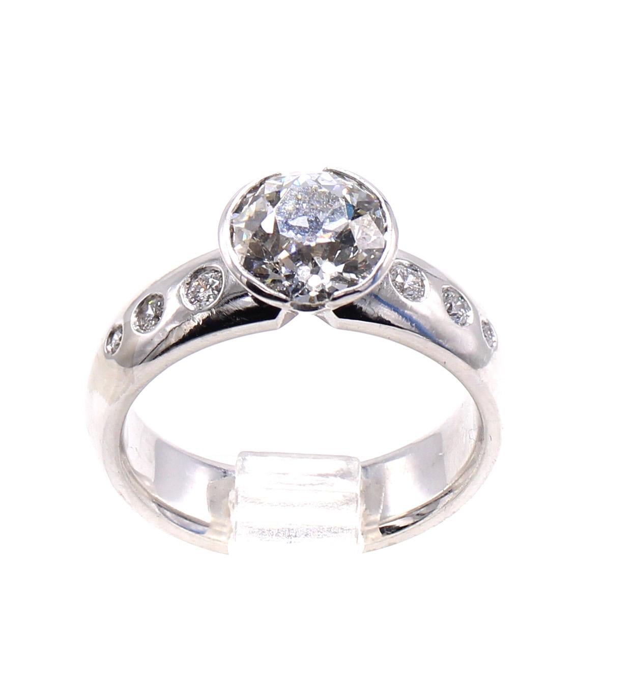 Beautifully designed and masterfully handcrafted in palladium this unique engagement ring has been created to incorporate a part of the new and the old world. The central diamond is a beautifully cut Old European cut diamond weighing 1.77 carats,