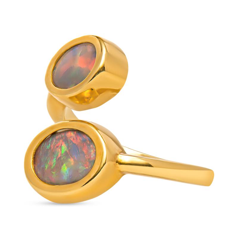 This unique bypass ring features 1.77 carat total weight in two Lightning Ridge oval opals set in 18 karat yellow gold. The Lightning Ridge opals are very beautiful and as they hit the light, the color changes for a unique look. It is a size 6.5 but