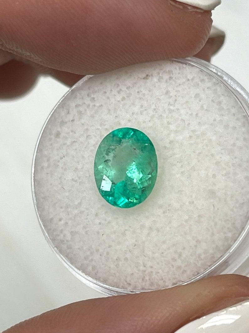 Stone: Emerald
Weight: 1.77-carats
Shape: Oval Cut
Clarity: Transparent
Luster: Very Good
Color: Medium Light Green
Measurements: 9.26mm x 7.44mm x 4.75mm
Geographic Origin: Colombia
Treatment: Natural, Oiling

Comments: Due to their growth